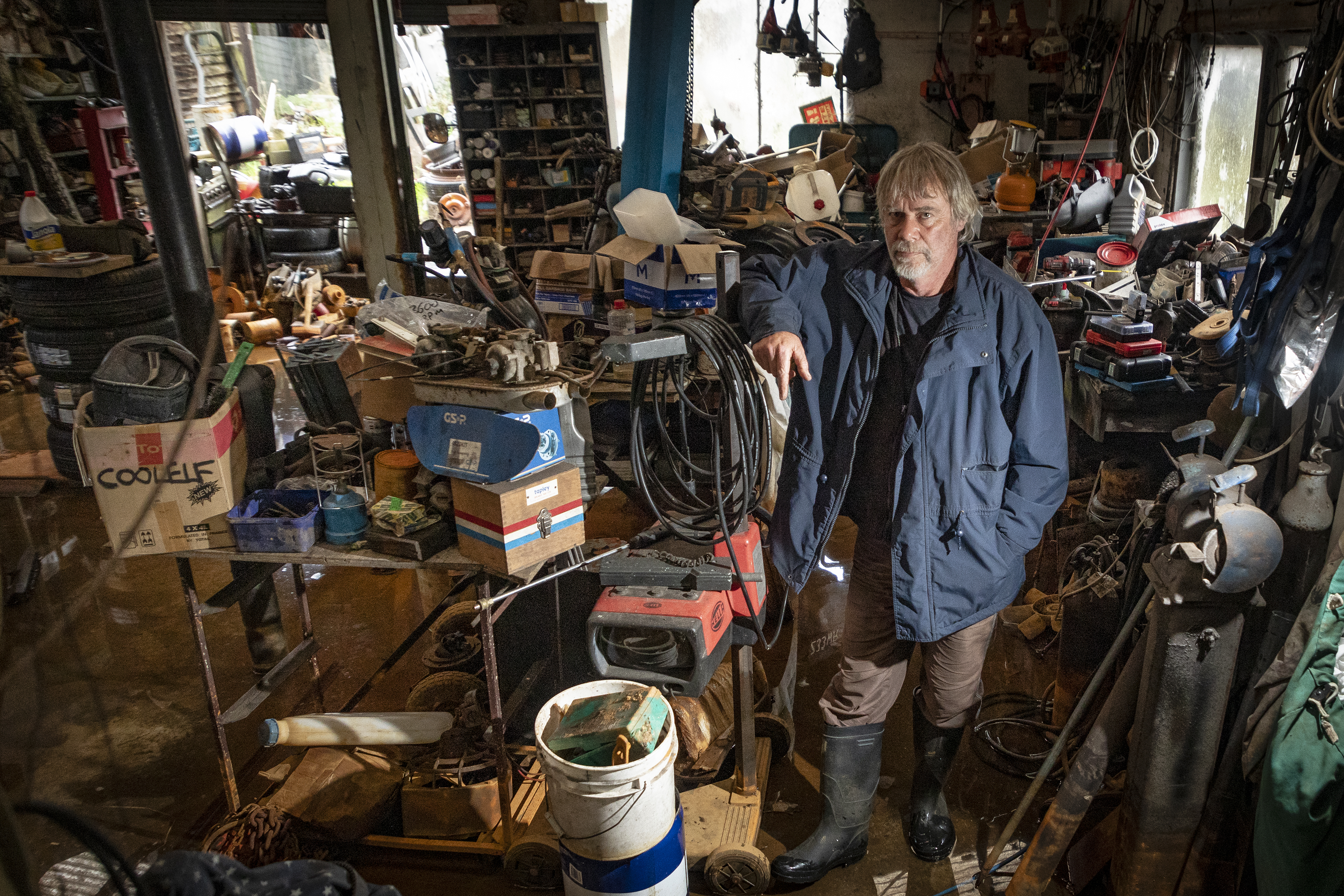Not been able to work since March, Bryce Allan stands in his flooded garage. Photo / Andrew Warner