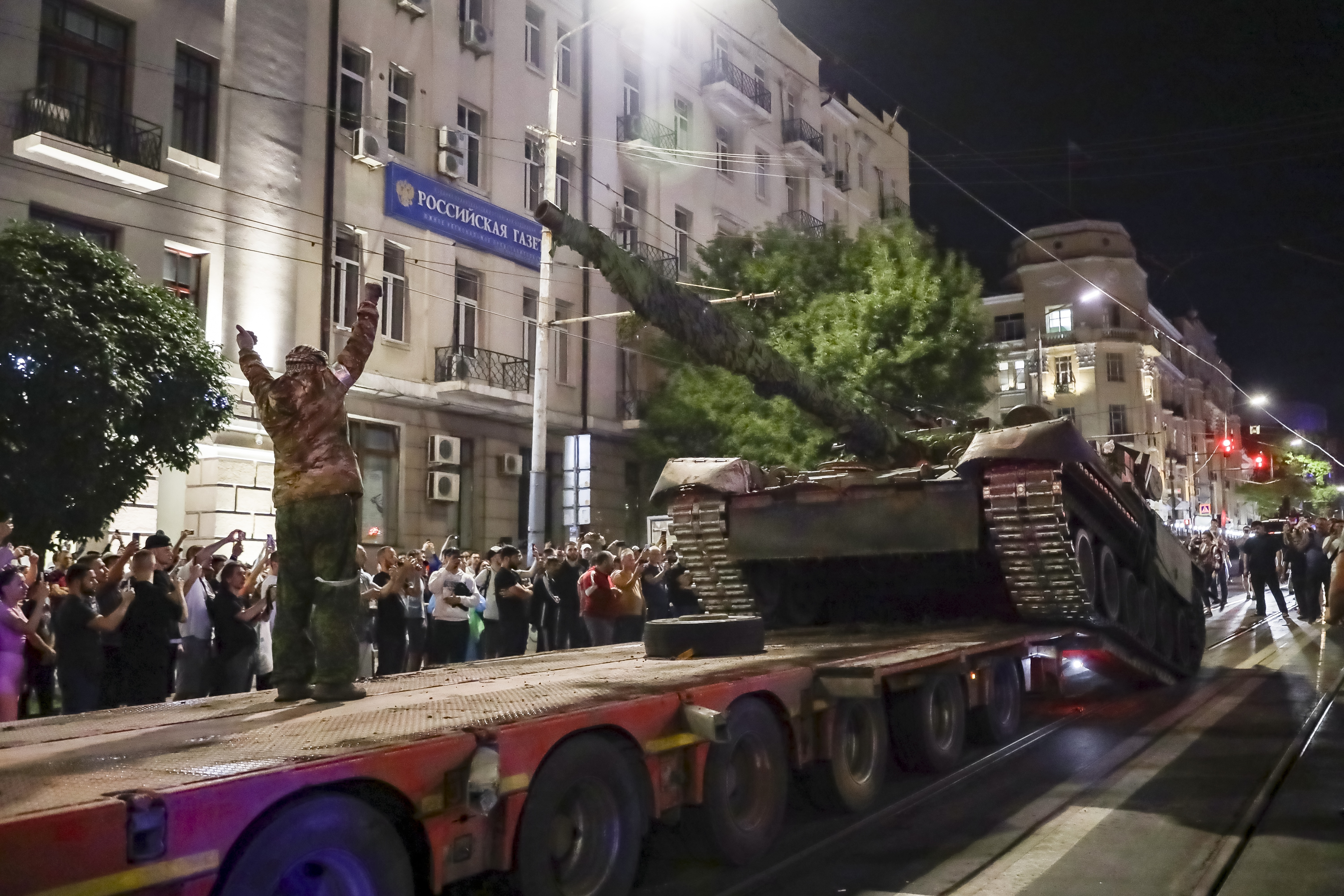 Members of the Wagner Group military company load their tank onto a truck on a street in Rostov-on-Don, Russia, on Saturday. Photo / AP
