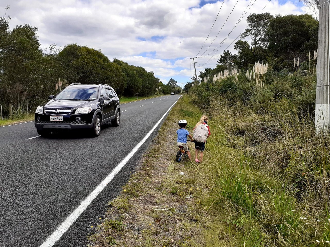 Children walking to school, squeezed between cars and an open drain, on Kauri Rd in Whenuapai. Photo / Supplied
