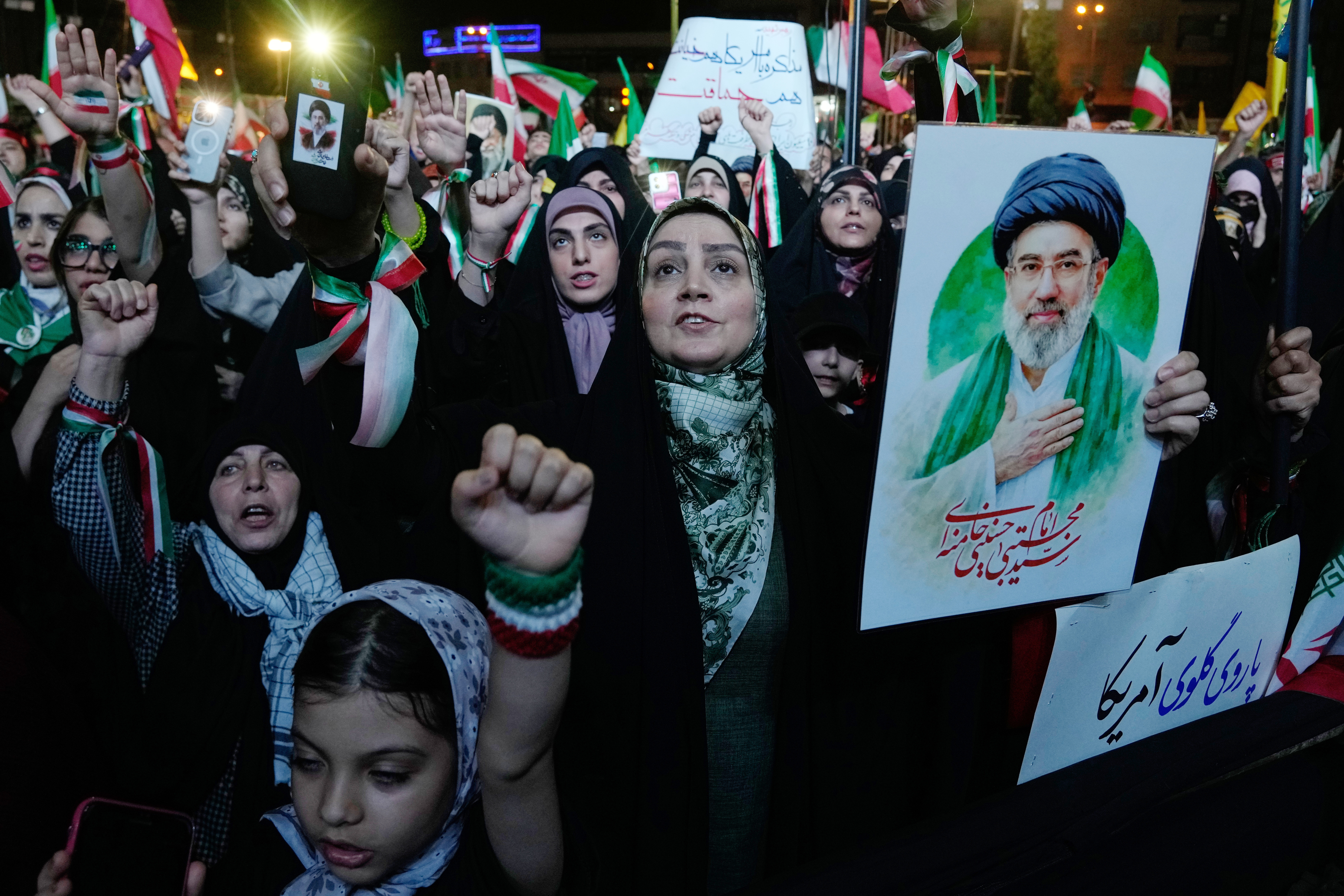 Pro-government demonstrators chant slogans as one of them holds a poster of the Iranian Supreme Leader Ayatollah Mojtaba Khamenei during their gathering at Enqelab-e-Eslami, or Islamic Revolution, square in Tehran, Iran, Monday, May 4, 2026. 