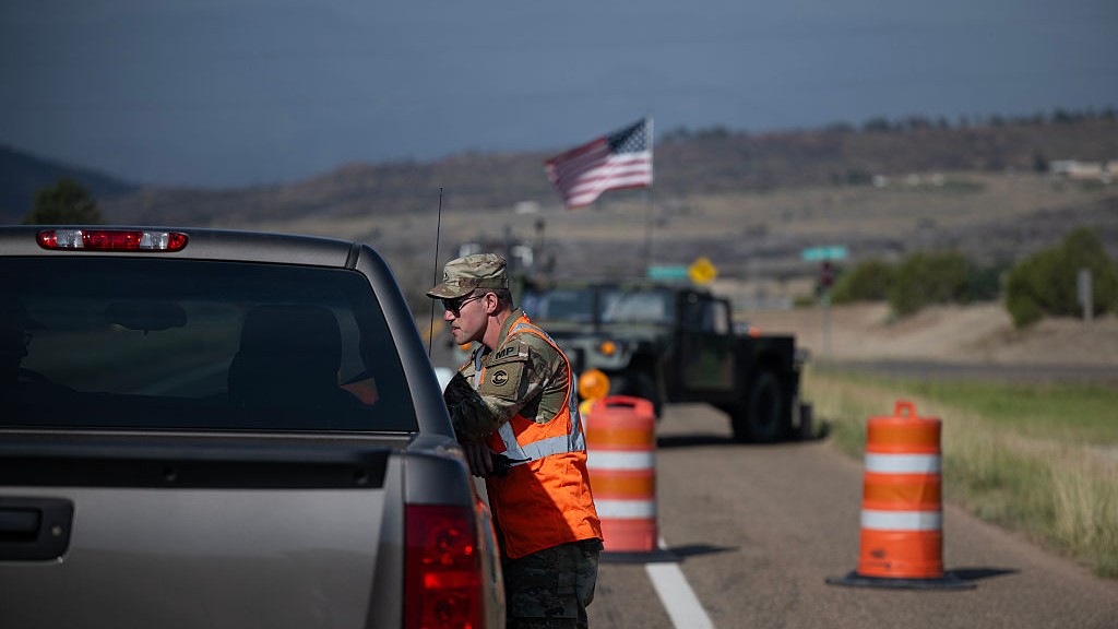 A Colorado National Guard member talks with residents trying to get back to their home in the burn area of the Aspen Acres fire, at a checkpoint on Colorado Highway 78 on July 10.