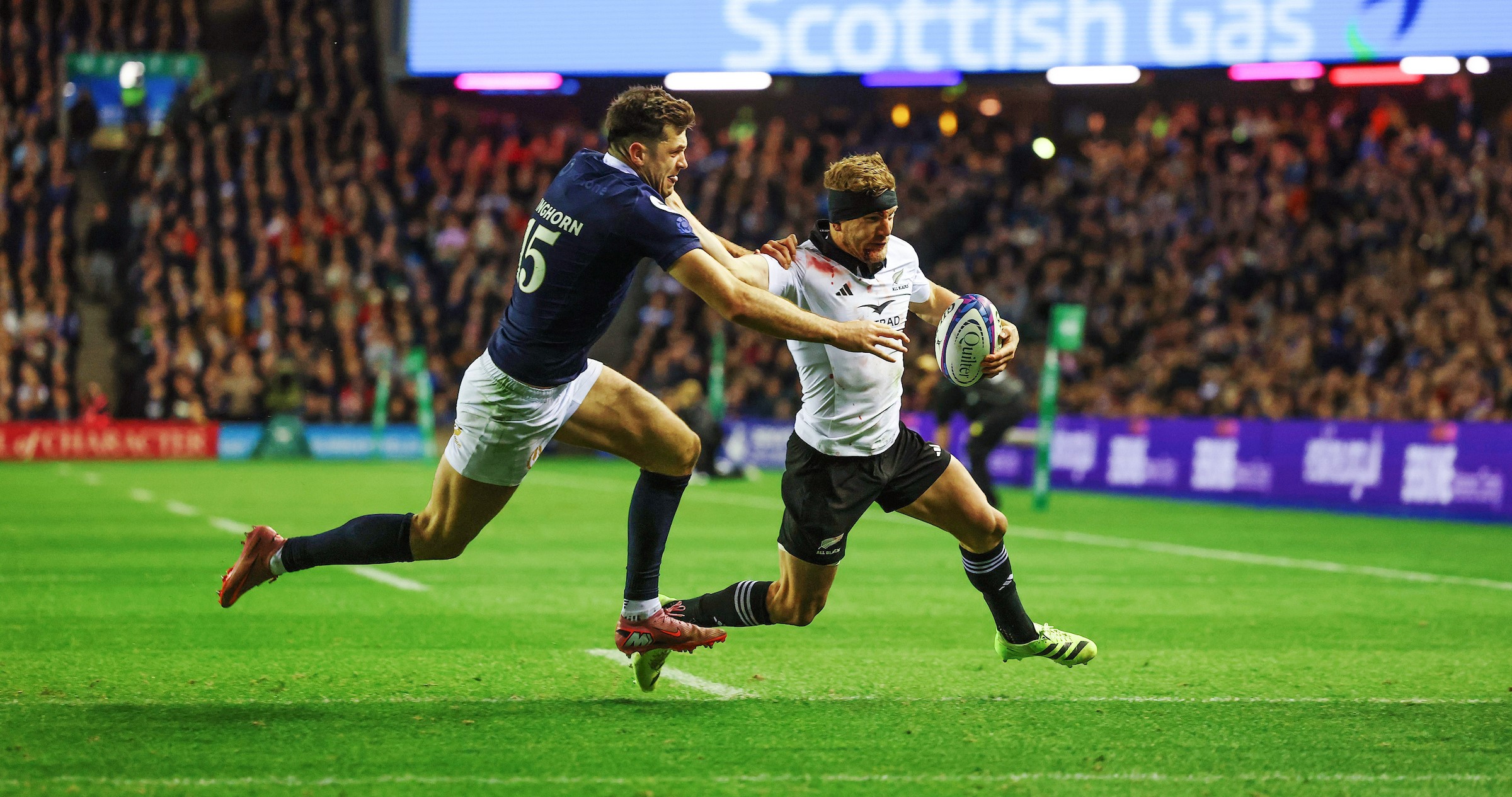 All Blacks replacement Damian McKenzie holds off Scotland's Blair Kinghorn on his way to the tryline at Murrayfield.