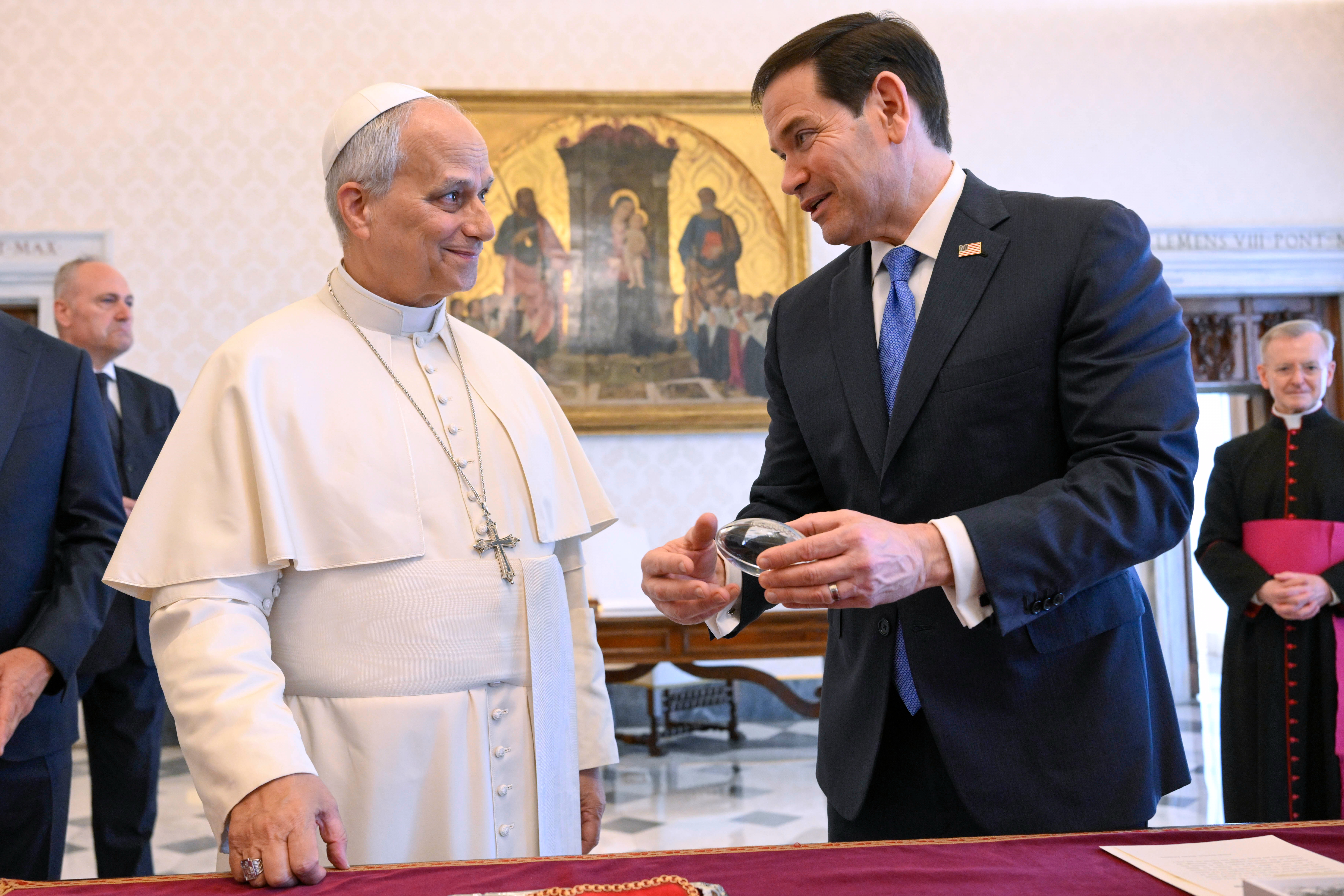 In this handout photo provided by Vatican Media Pope Leo XIV exchanges gifts with US Secretary of State Marco Rubio, right, as they meet in the pope's private library at the Vatican. 