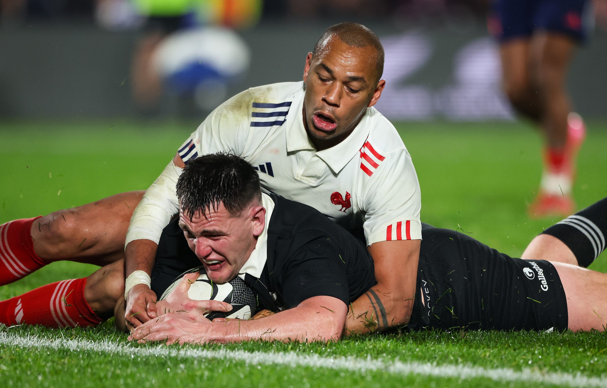 Brodie McAlister slides in for his try despite the attempted tackle by French skipper Gael Fickou.
