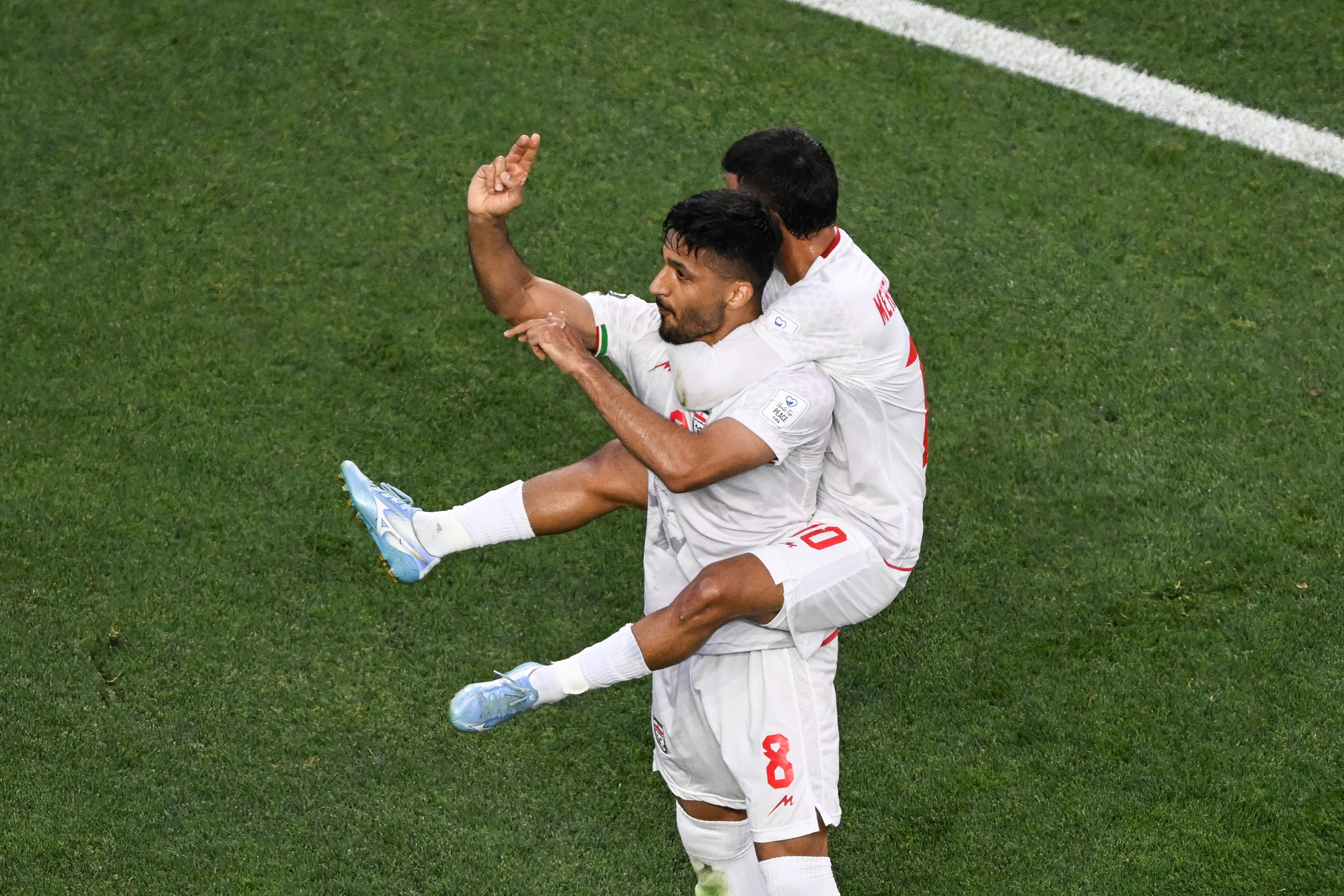 Mohammad Mohebbi of Iran celebrates his goal against New Zealand with Mehdi Ghayedi of Iran.