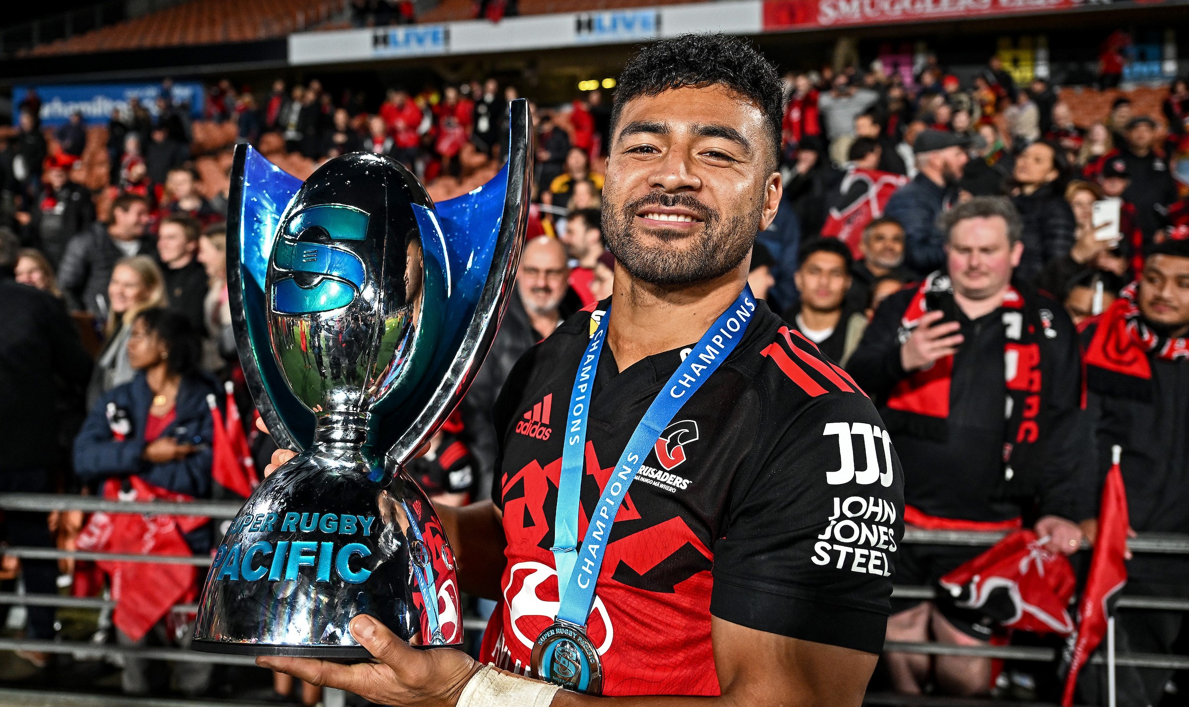 Richie Mo'unga celebrates with the Super Rugby Pacific trophy after the Crusaders beat the Chiefs in Hamilton in 2023.