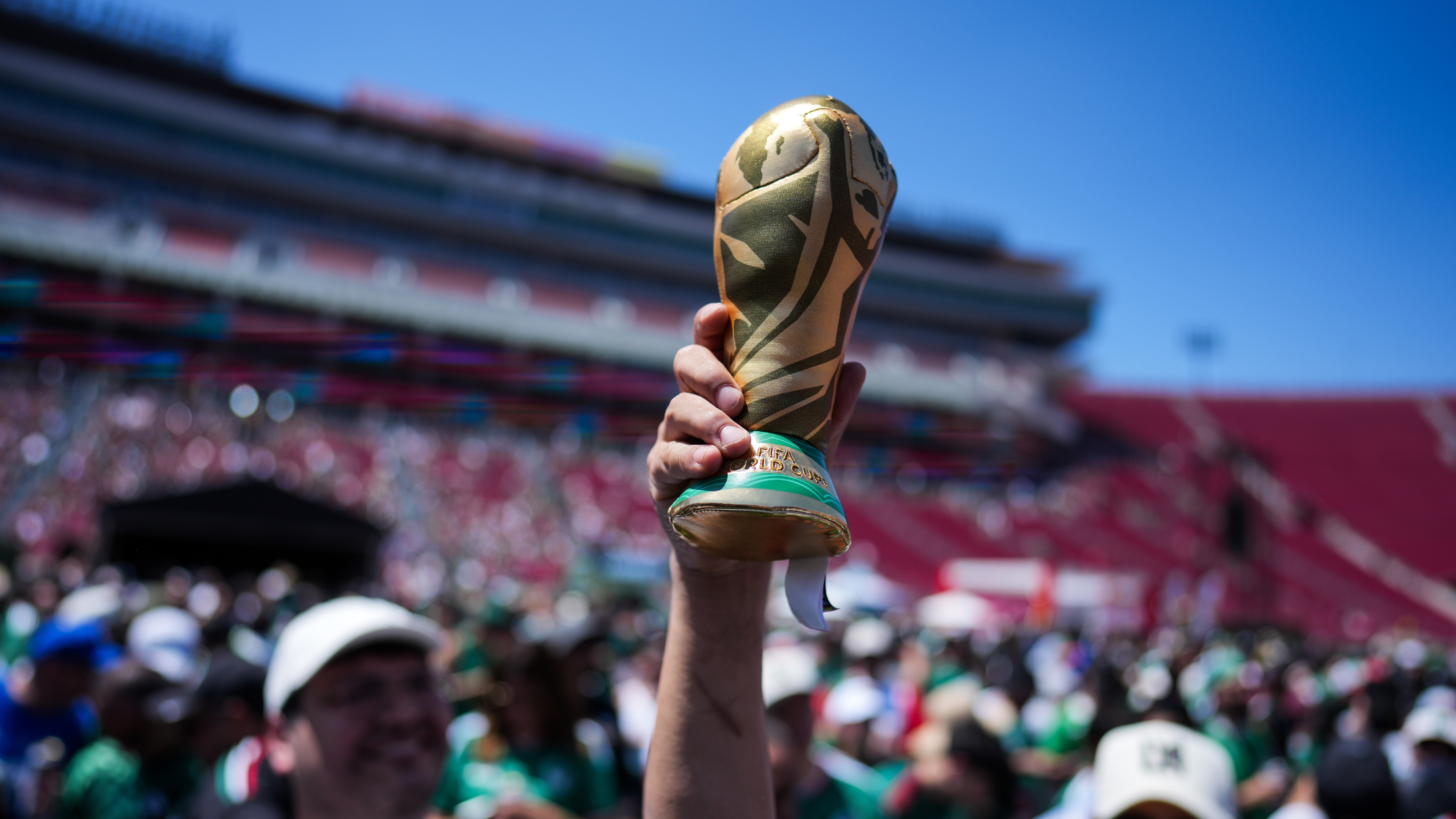 A fan holds up a replica of the World Cup trophy at a fan festival at the Los Angeles Memorial Coliseum in Los Angeles, Thursday, June 11, 2026, during a live broadcast of the World Cup soccer match between Mexico and South Africa.
