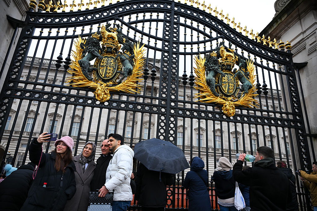 Tourists are seen outside Buckingham Palace on the day Britain's former prince Andrew was arrested on suspicion of misconduct.