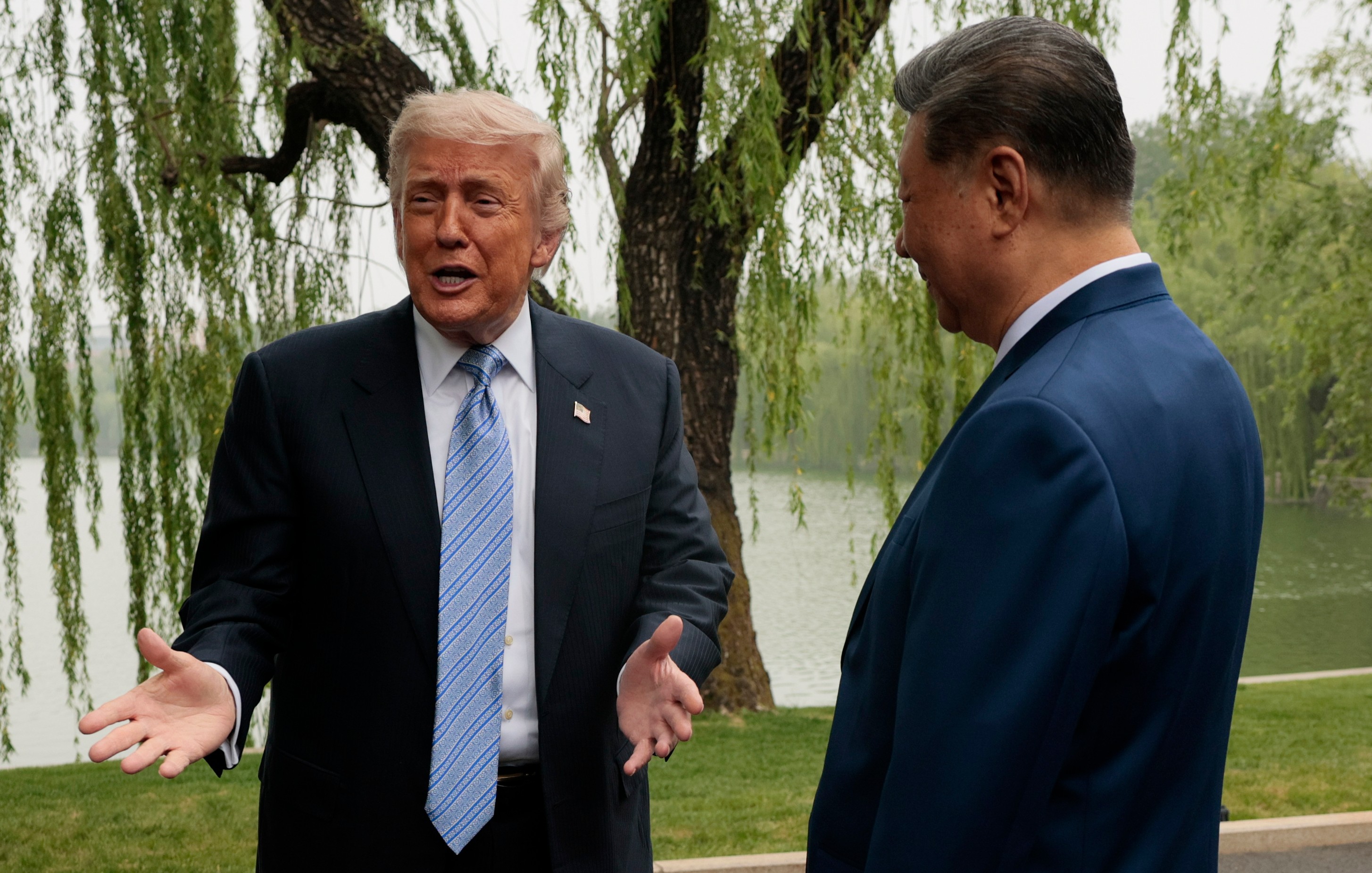 US President Donald Trump, left, speaks as he is greeted by Chinese President Xi Jinping at Zhongnanhai Garden in Beijing, China, Friday, May 15, 2026.