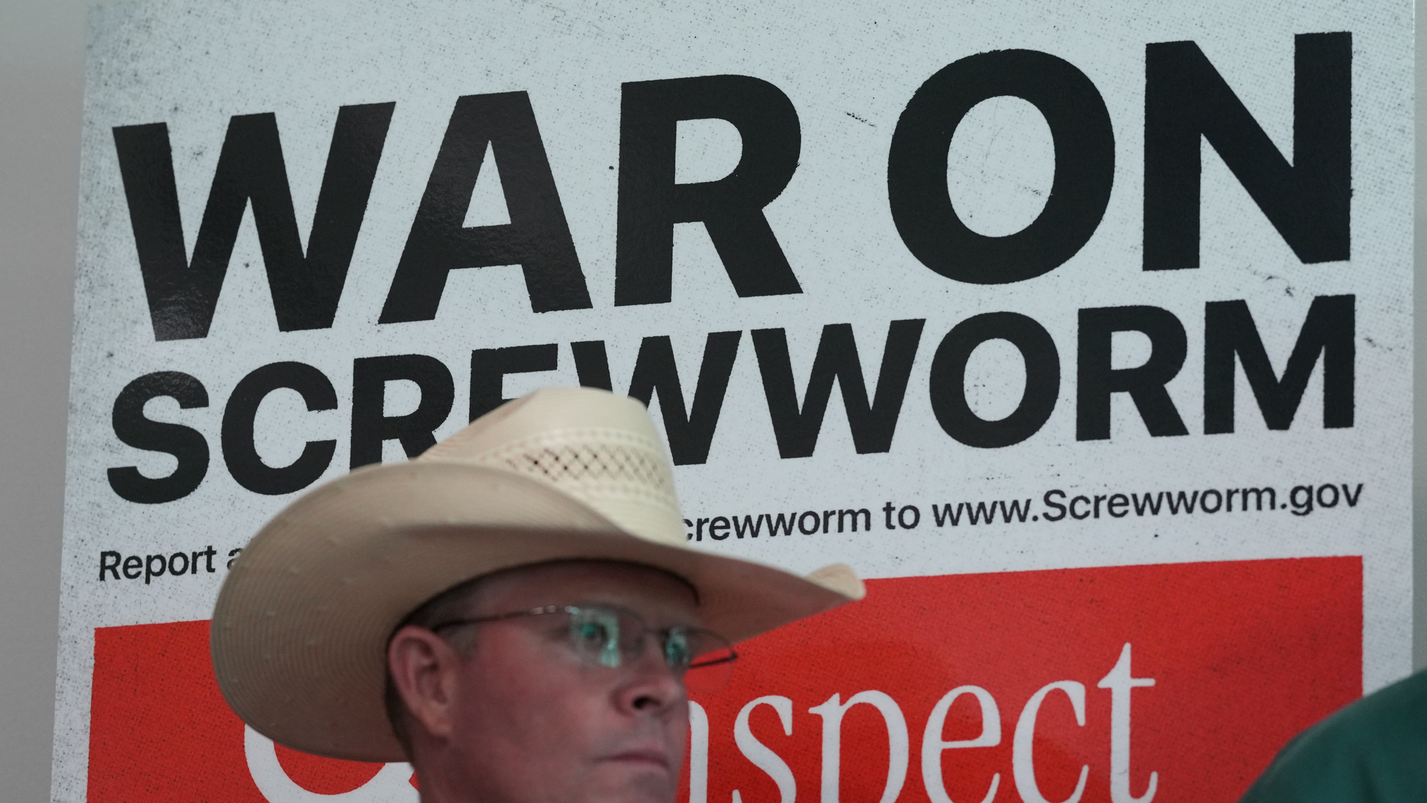 A rancher stands in front of signage as US Agriculture Secretary Brooke Rollins holds a news conference with ranchers, researchers and officials at the Knipling-Bushland US Livestock Insects Research Laboratory in Kerrville, Texas, Monday, June 8, 2026.