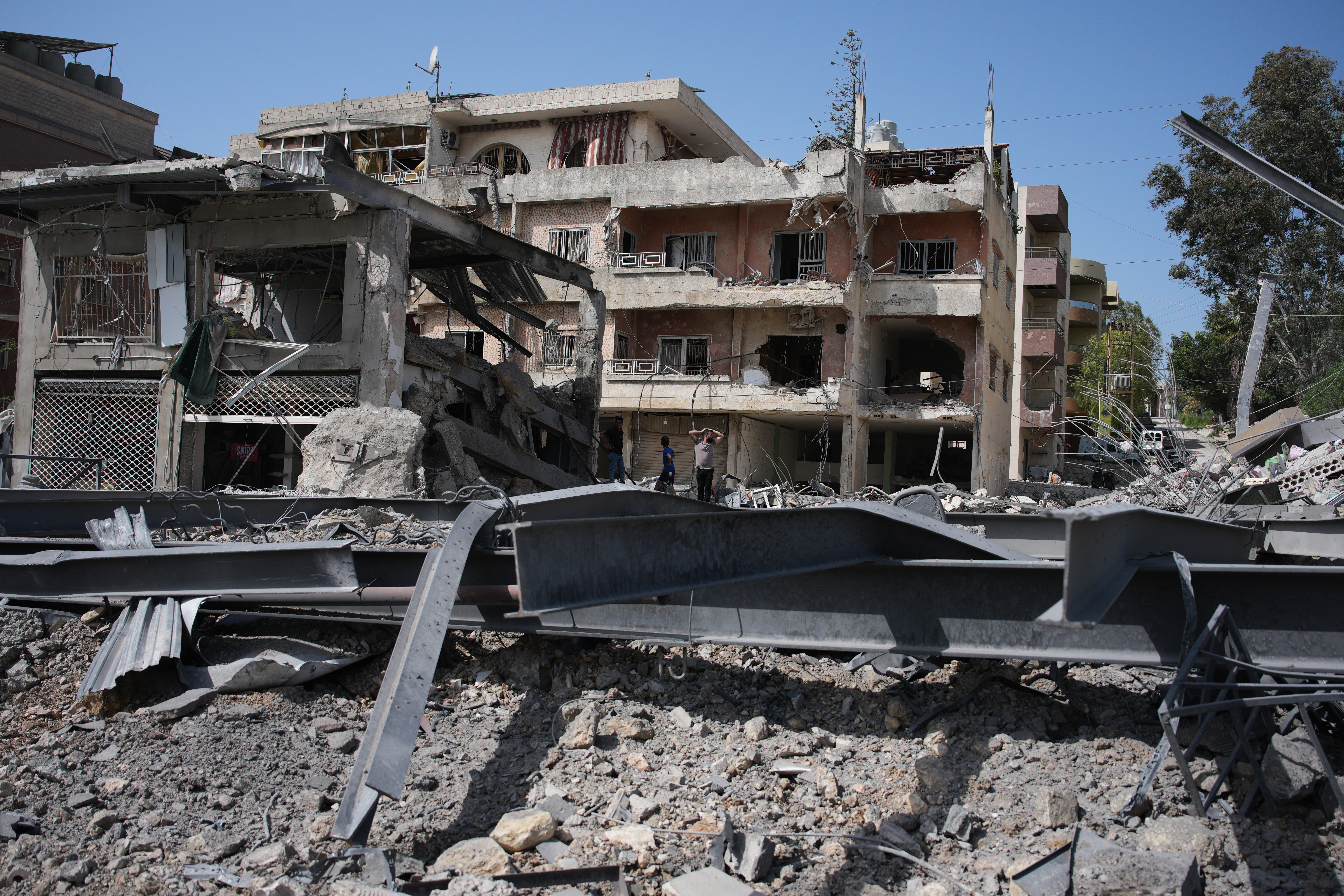 Lebanese residents inspect damage at the site of buildings destroyed in Israeli airstrike.
