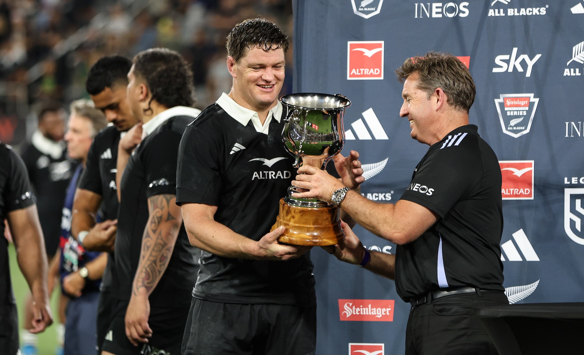 Mark Robinson hands All Blacks skipper Scott Barrett a trophy after his side's victory over Fiji in San Diego last year.