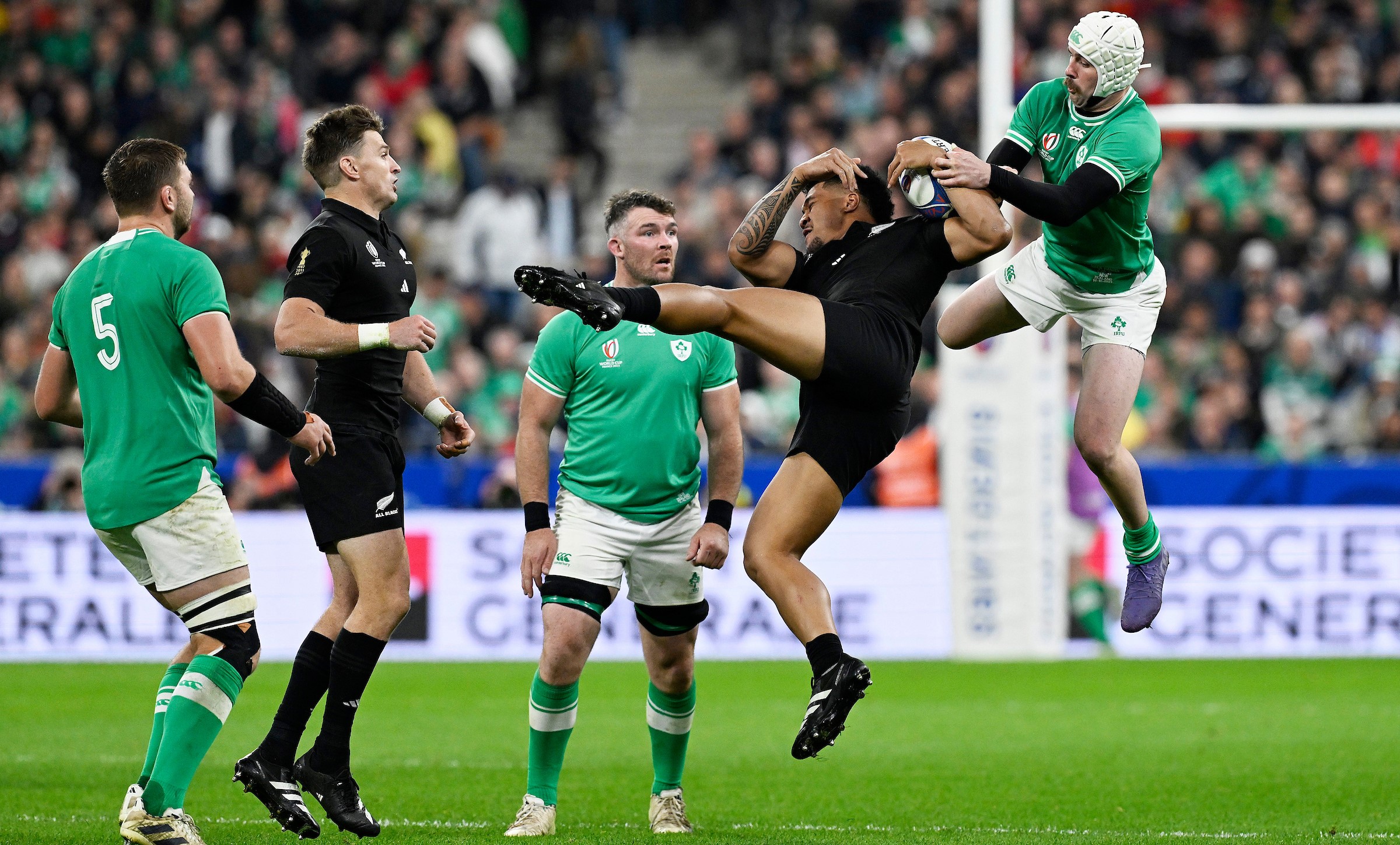 Leicester Fainga'anuku wins the ball despite the intentions of Ireland's Mack Hansen during the 2023 World Cup quarter-final.