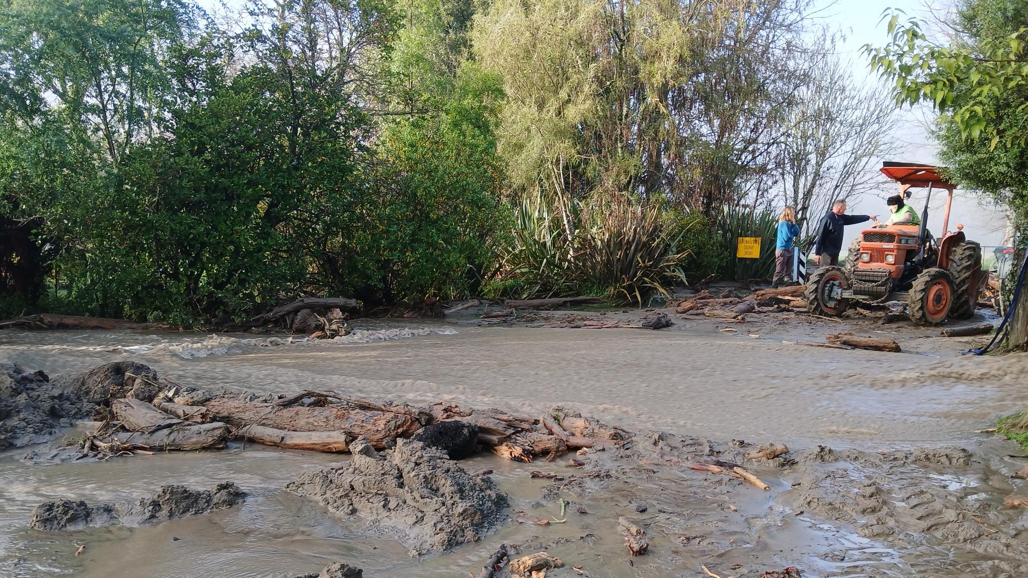 Locals clean up the road with their tractors next to Ngatimoti school on Saturday.