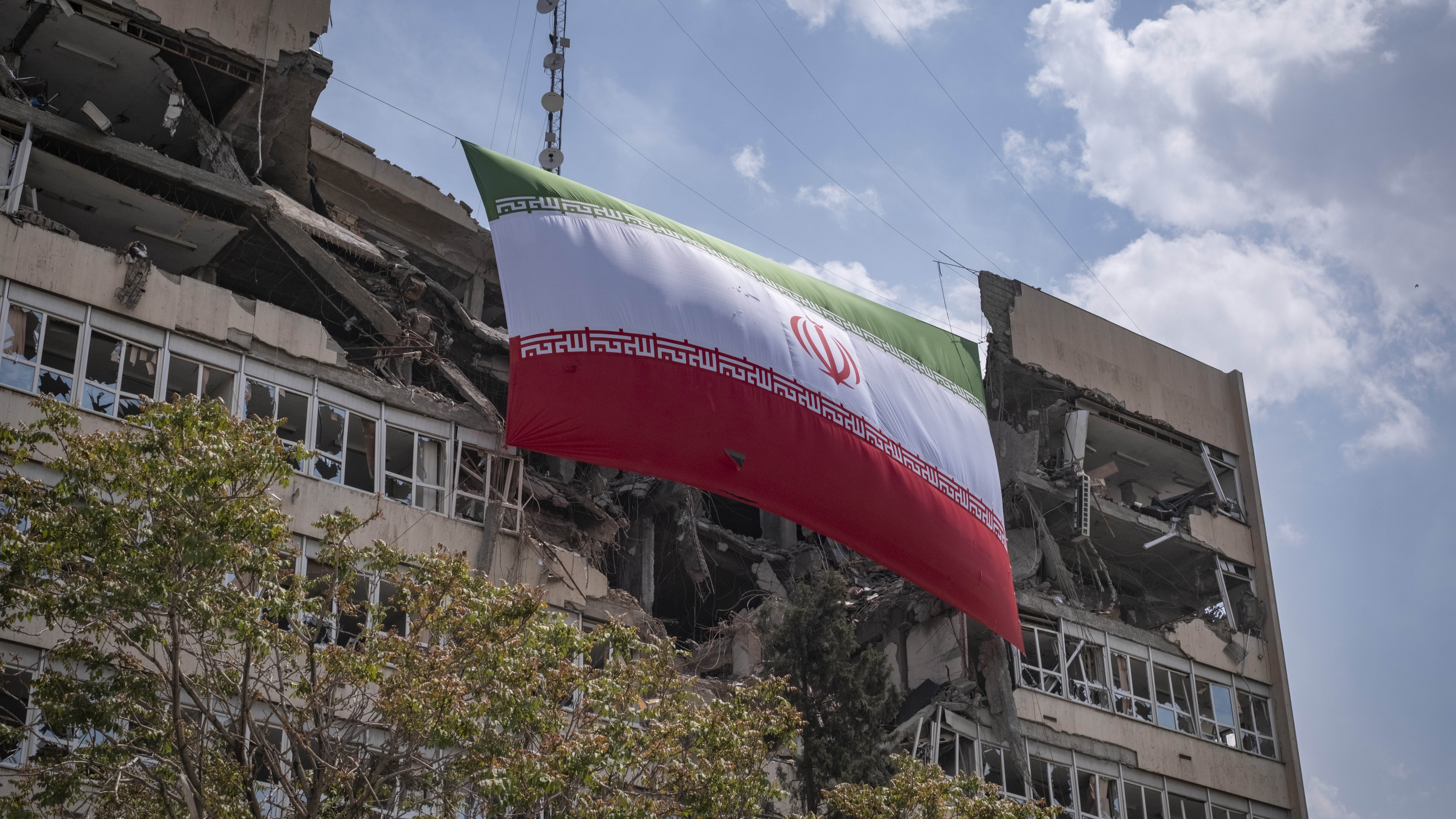 An Iranian national flag hangs from the Judiciary's headquarters, which was damaged in a military operation in Tehran, Iran, on April 20, 2026.