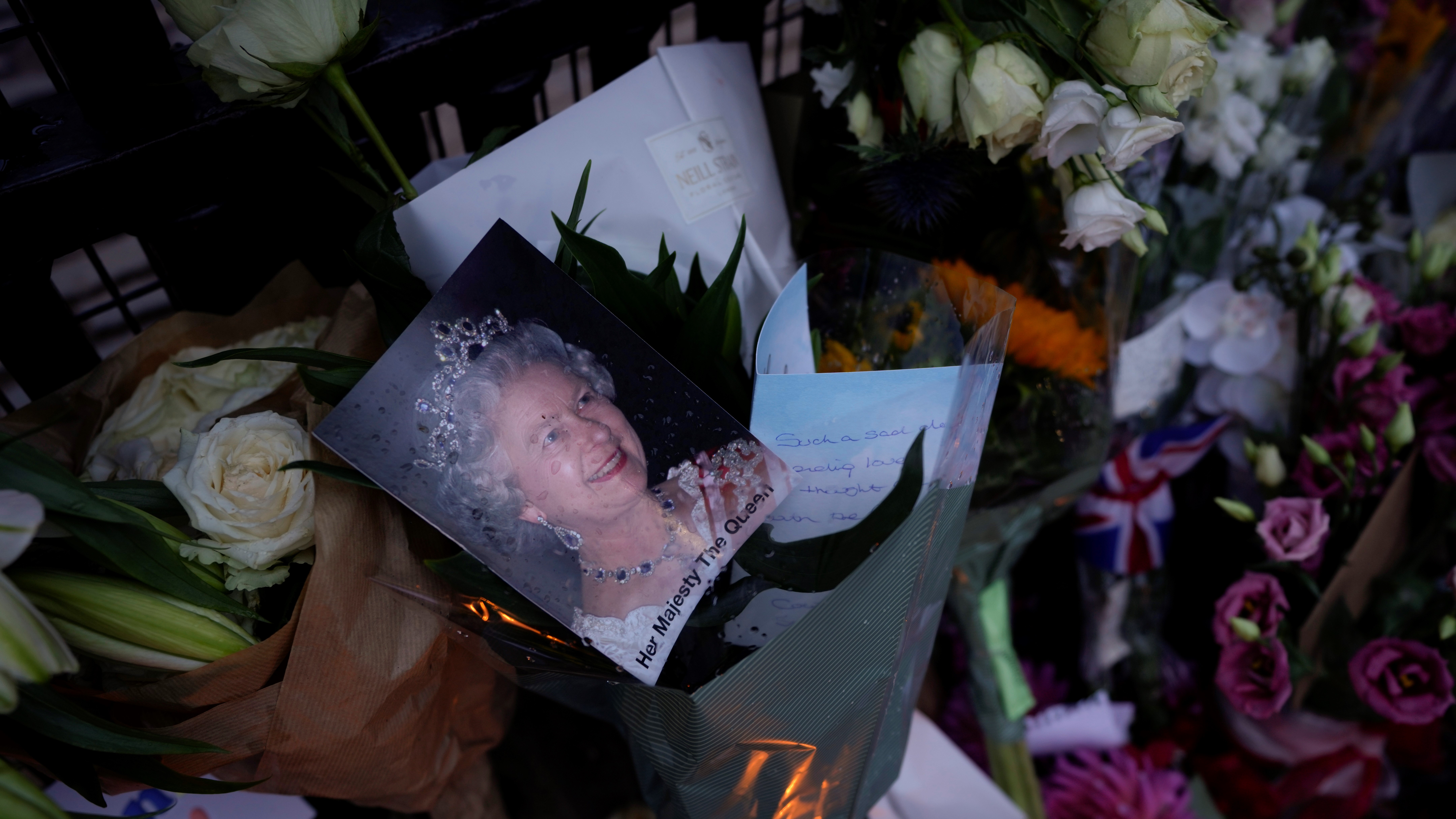 Messages, flowers and candles are seen at the gates of Buckingham Palace in London