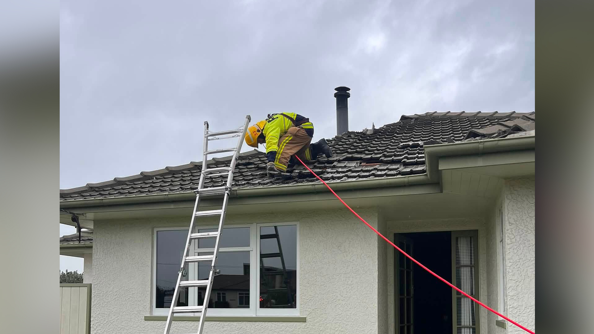 A firefighter securing a roof damaged by a miniature tornado in Richmond, south of Nelson. (Source: Richmond Volunteer Fire Brigade)