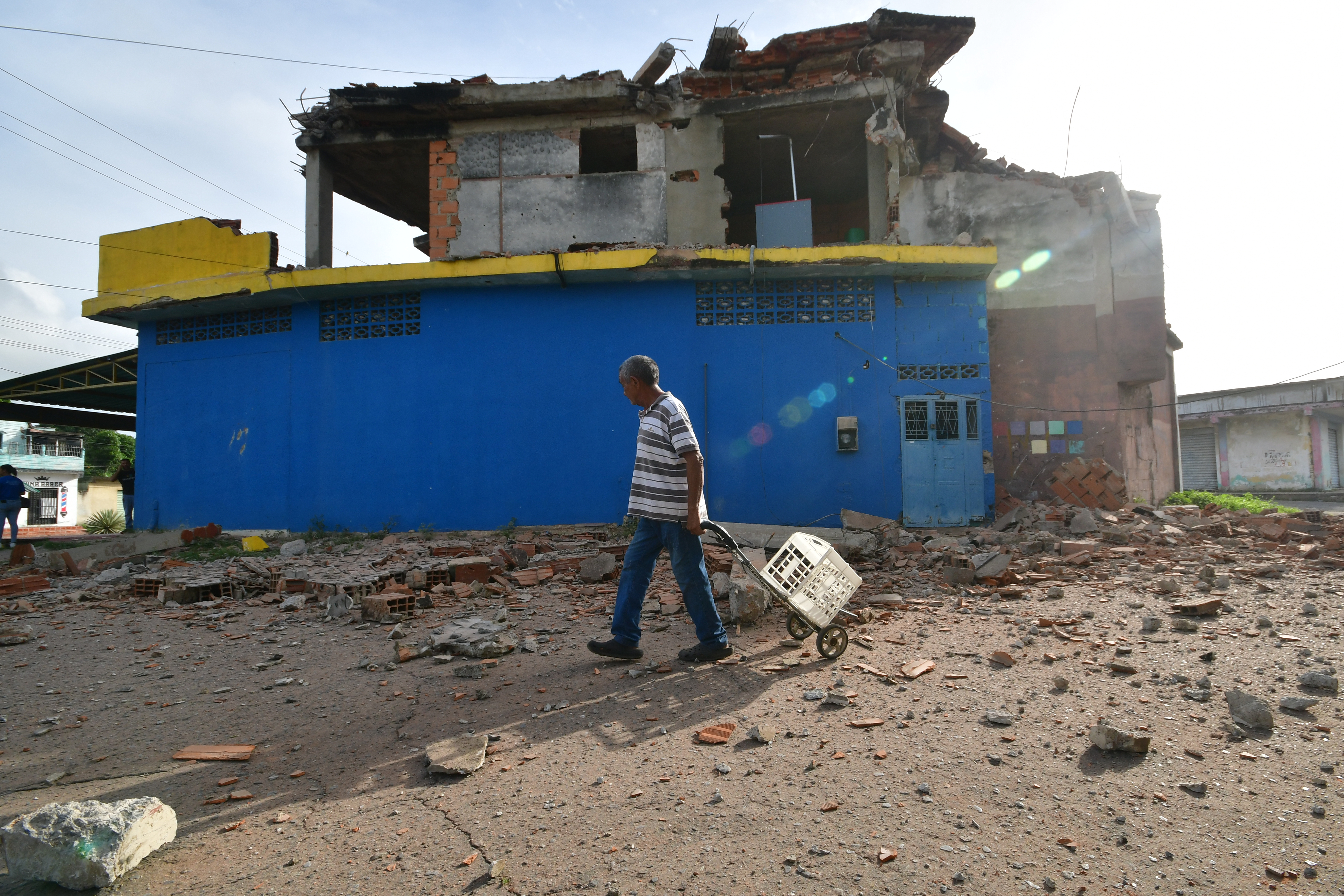 A man walks past a damaged home in Moron, near the epicenter of two earthquakes that struck Venezuela the day before, Thursday, June 25, 2026.