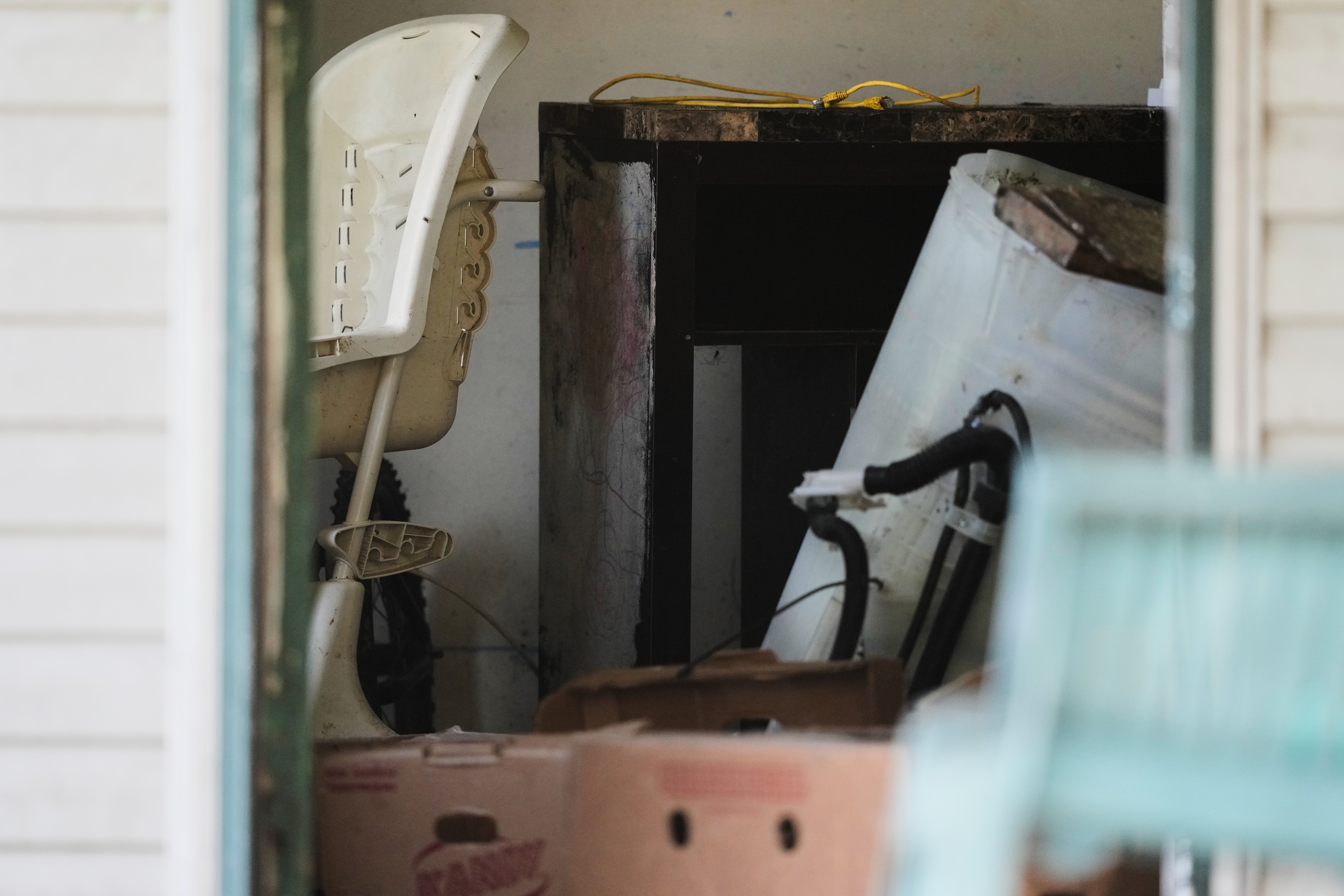 Items including a high chair, left, are seen in a home where authorities say they removed 16 children and arrested four adults in Hamden, Ohio, Wednesday, July 1, 2026.