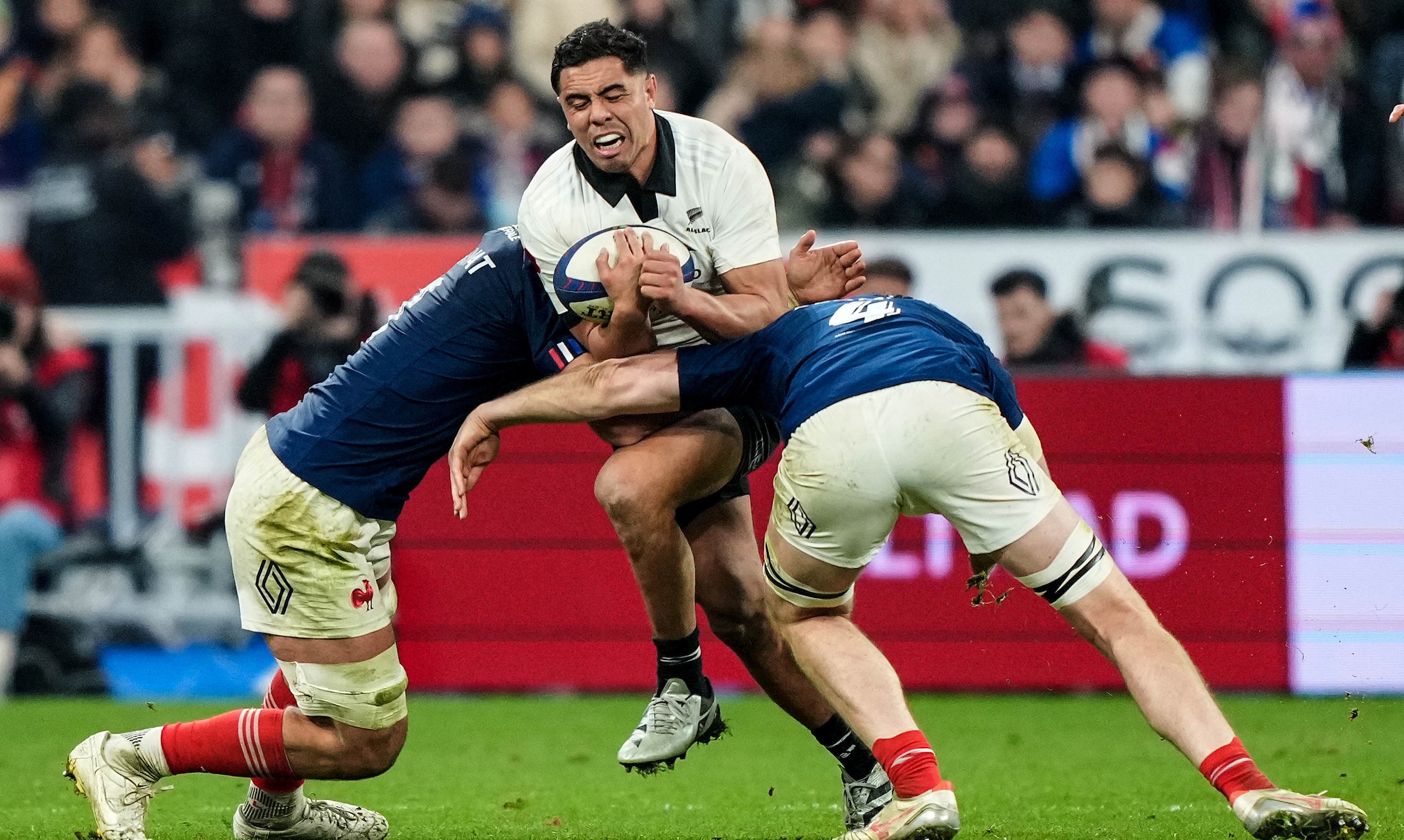 All Blacks midfielder Anton Lienert-Brown is well contained by the French defence at the Stade de France.