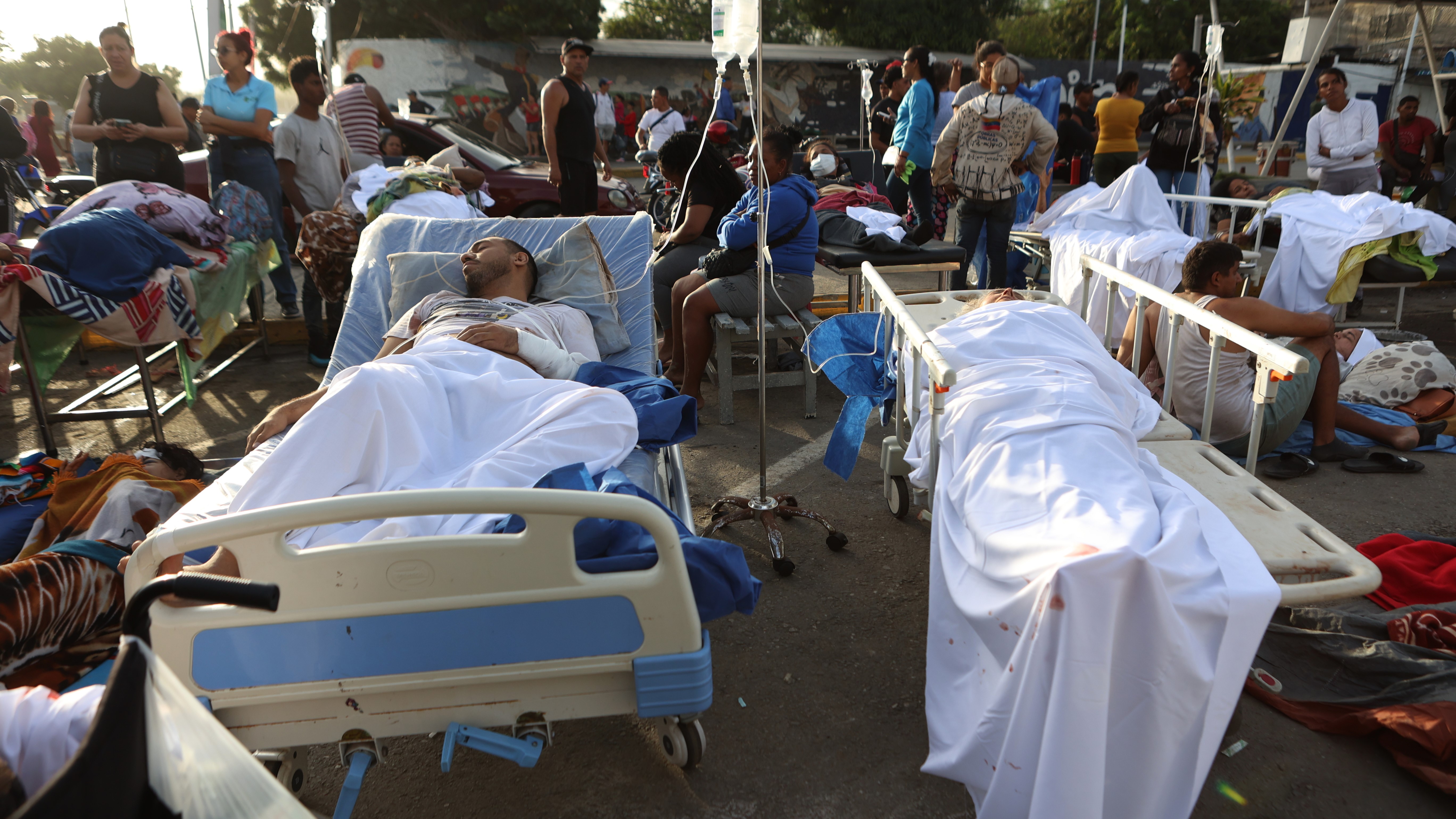 Patients lie outside a hospital evacuated after it was damaged in an earthquake in Catia La Mar, Venezuela.