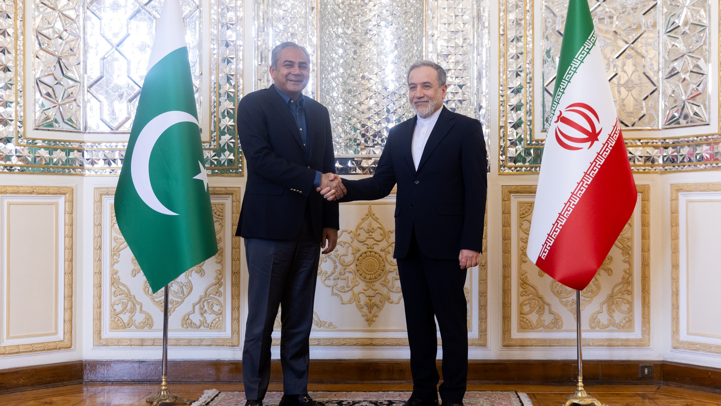  Iranian Foreign Minister Abbas Araghchi and Pakistani Interior Minister Mohsin Naqvi shake hands during a meeting.