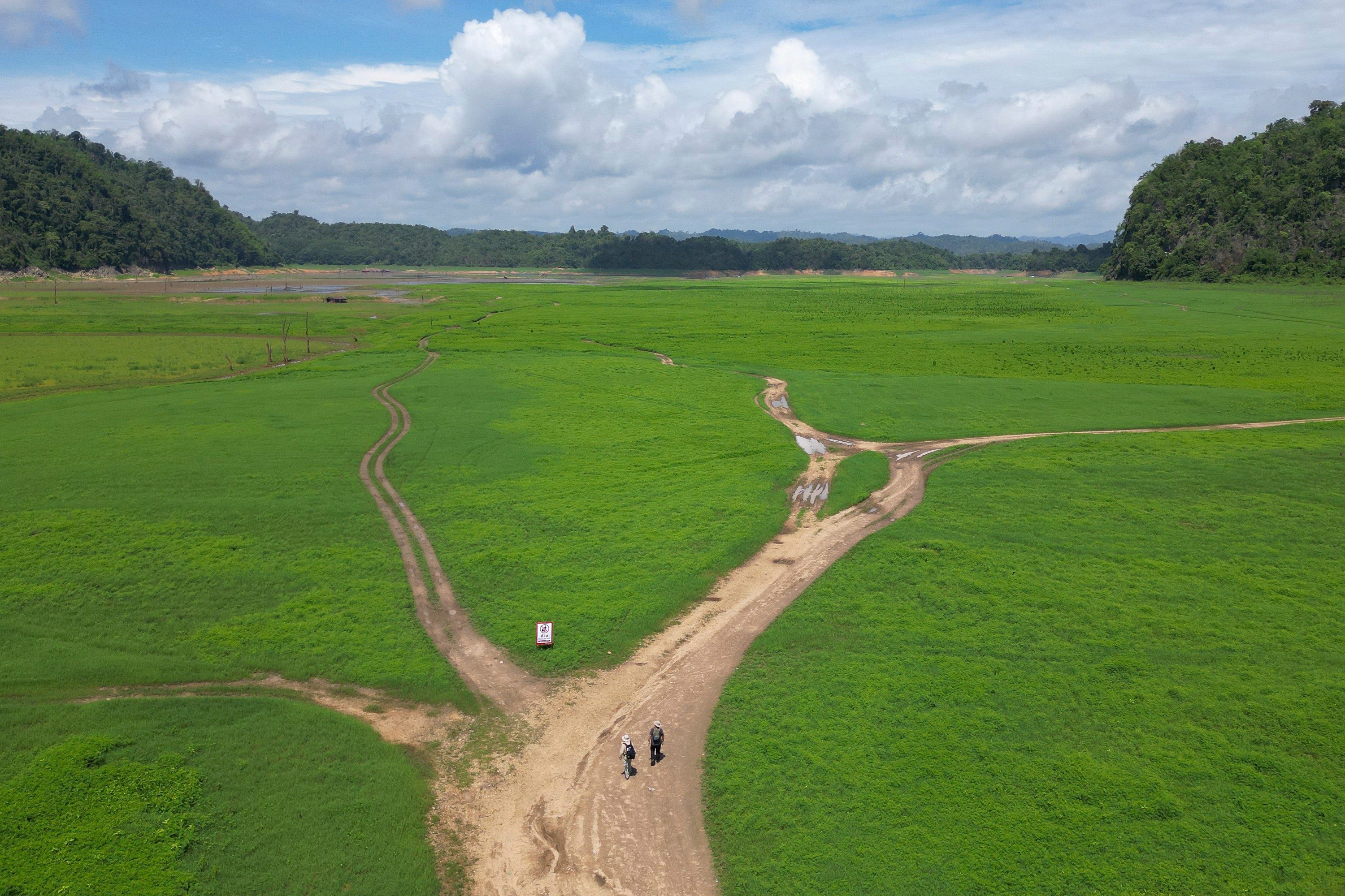 Researchers walk into the empty reservoir where Nithe Station, a depot on World War II's infamous "Death Railway" resurfaced after the reservoir was drained in Sangkhlaburi, Thailand on Friday, May 29, 2026.