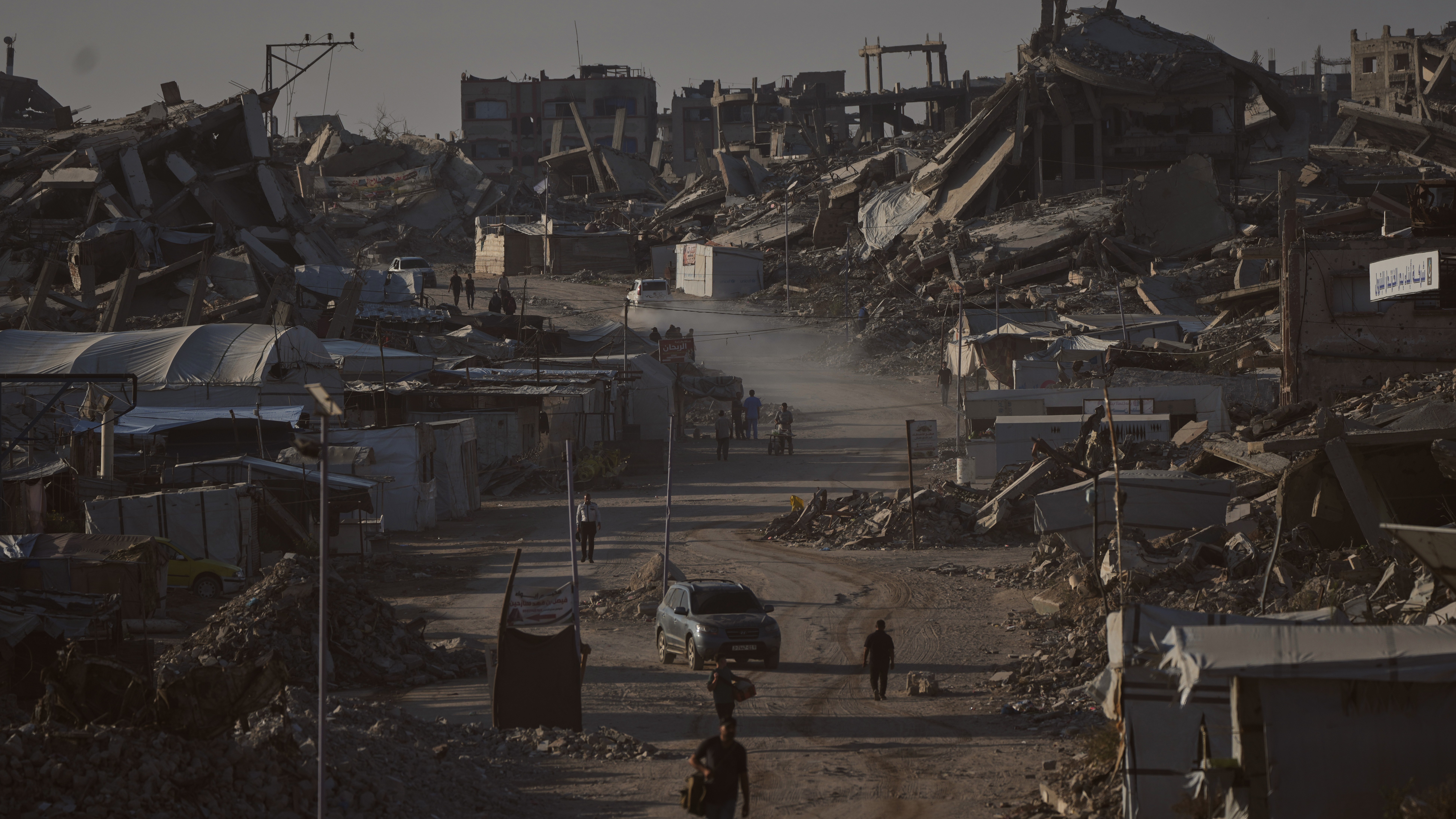 Palestinians walk along a road surrounded by buildings destroyed in Israeli military strikes during the Israel-Hamas war, in Jabaliya, Gaza Strip, Thursday, July 2, 2026.