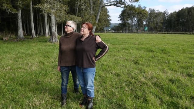 Sisters Heather Jean Bryham, left, and Linda Bryham. The current State Highway 1, in the background, passes between the two largest remaining stands of kahikatea.