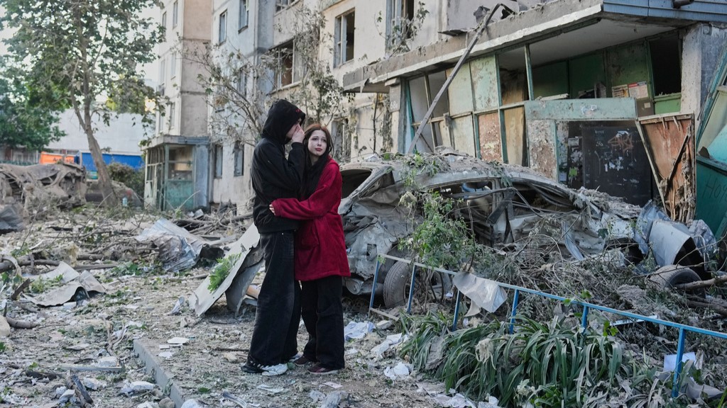 People react as they look at the site of a Russian missile strike that hit a residential building in Kyiv, Ukraine, Tuesday, June 2, 2026.