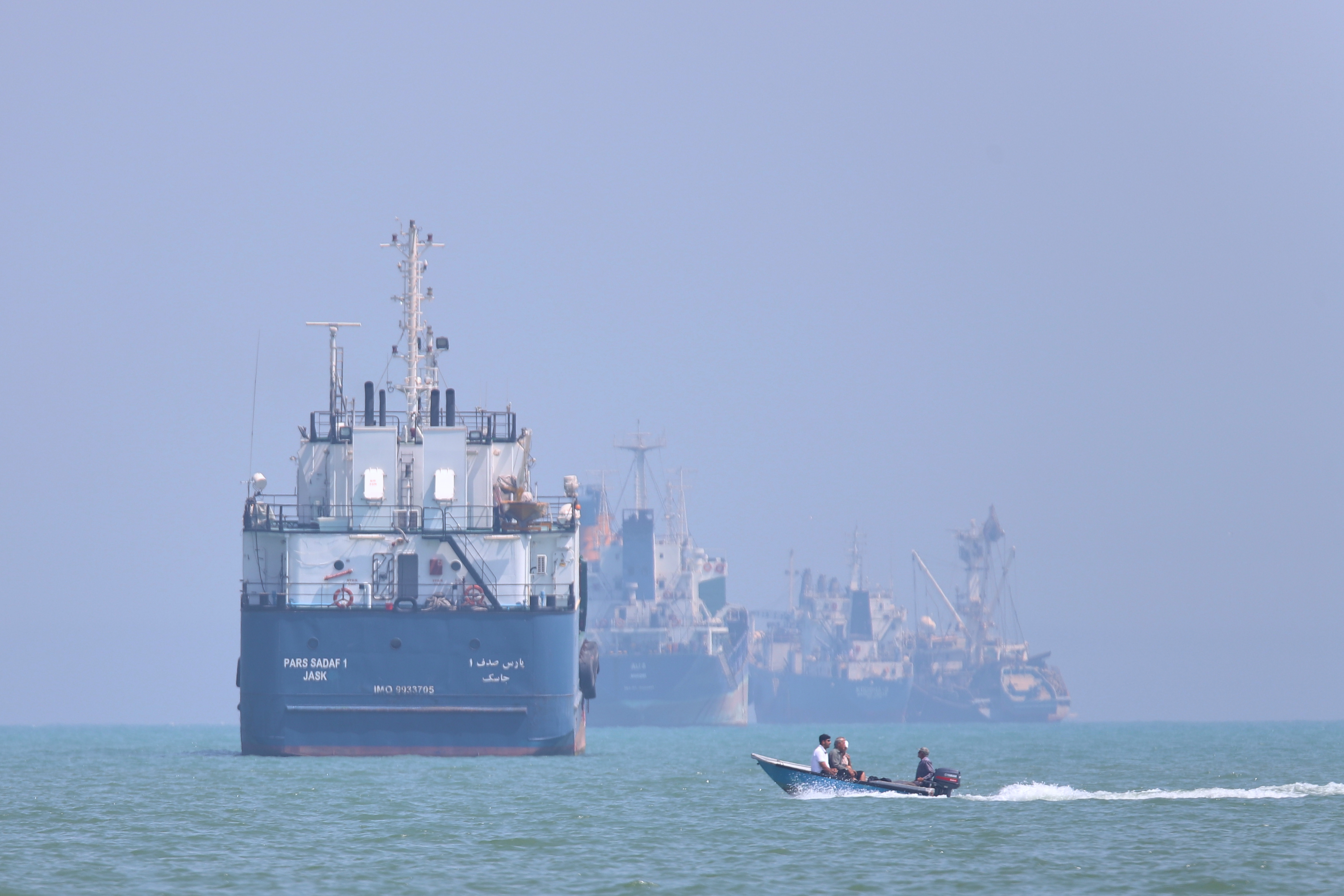A small motorboat passes anchored vessels in the Strait of Hormuz off Bandar Abbas, Iran, Thursday, June 11, 2026.