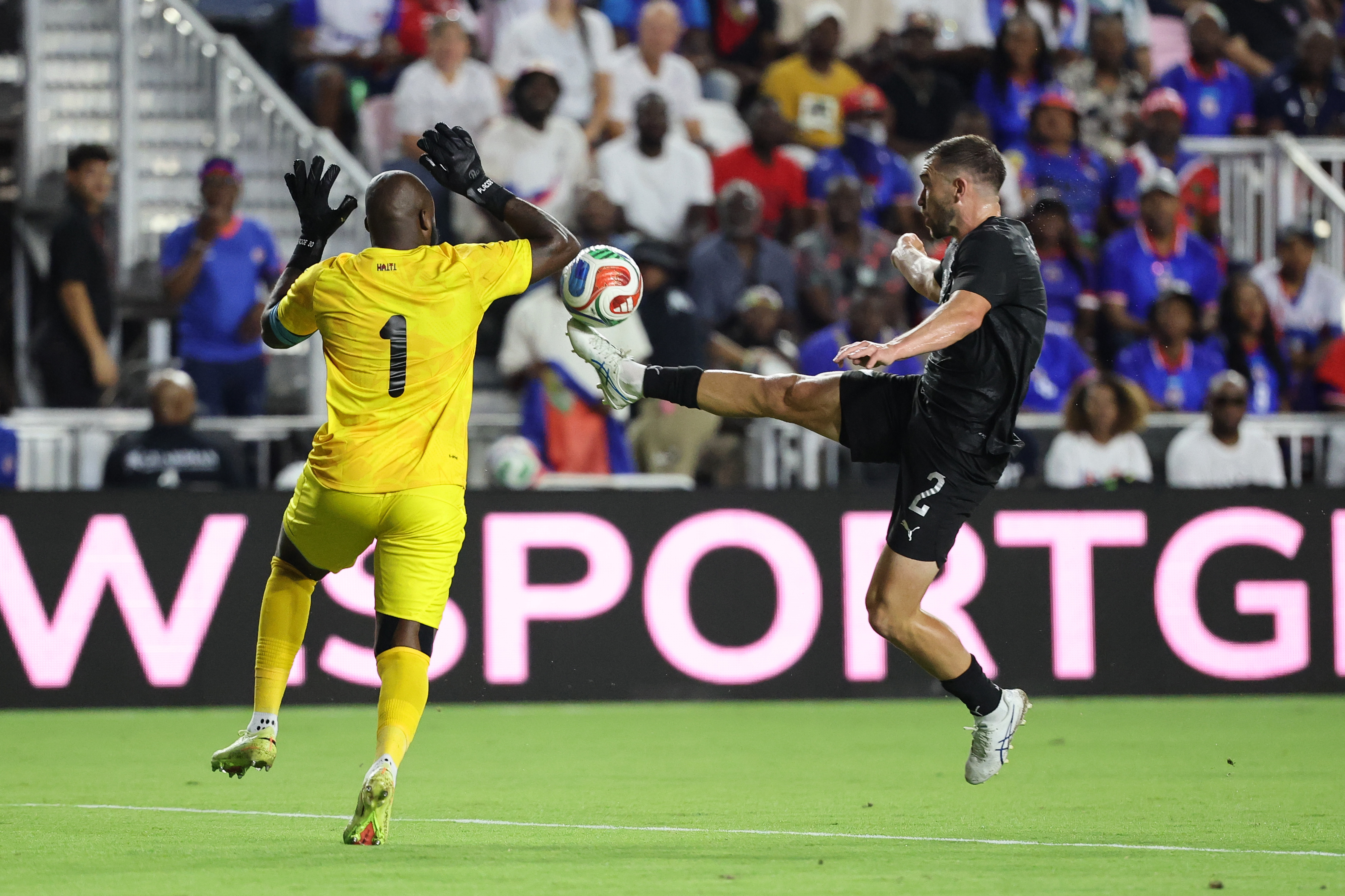 Tim Payne challenges the Haiti goalkeeper in their World Cup warm-up match in Florida.