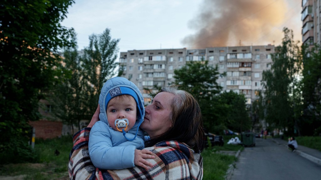 A woman carries a baby near a residential house damaged after a Russian strike in Kyiv, Ukraine, on Tuesday, June 2, 2026.