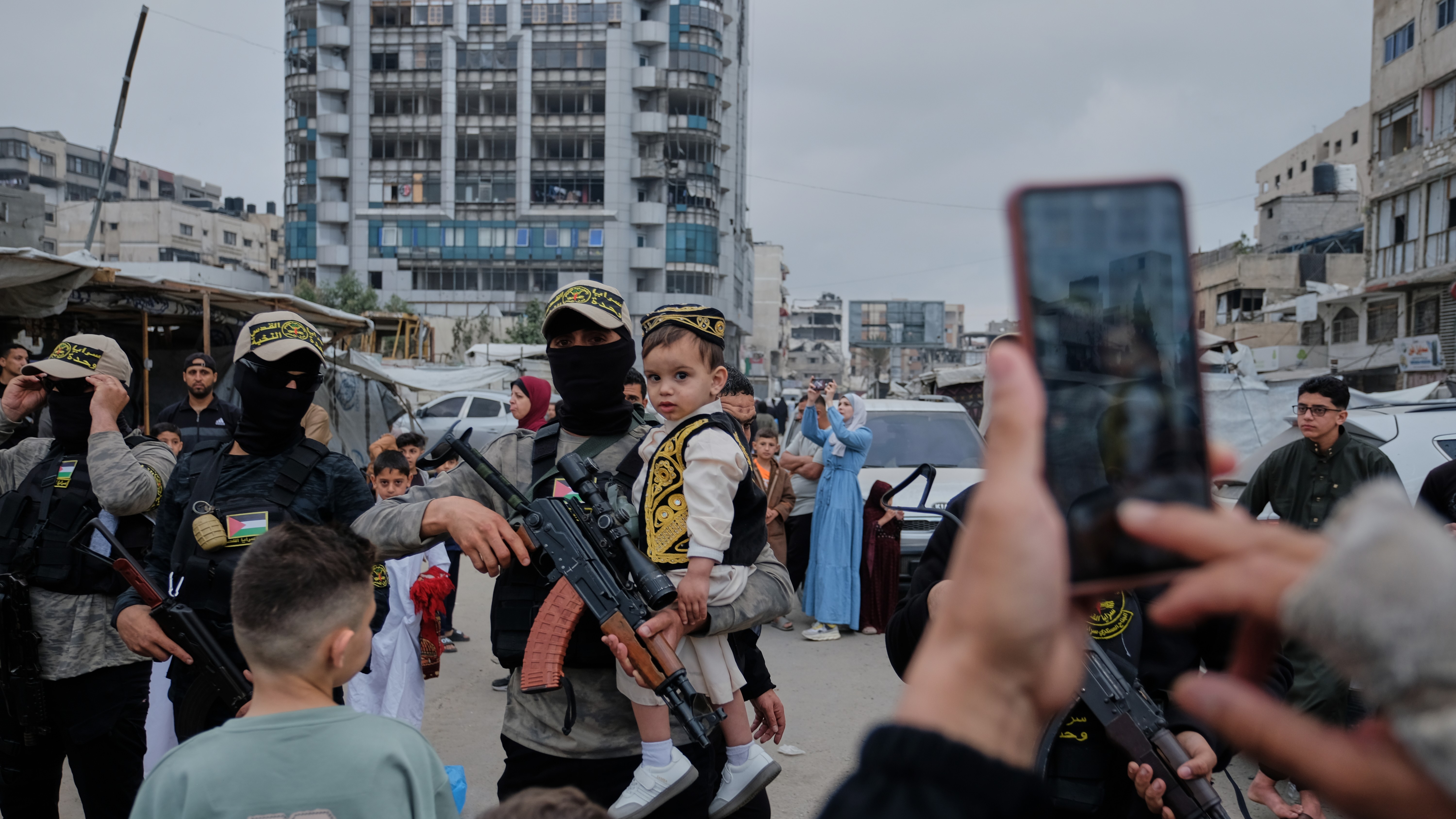 Palestinians take photos with Islamic Jihad militants as they gather for Eid al-Adha prayers in Gaza.