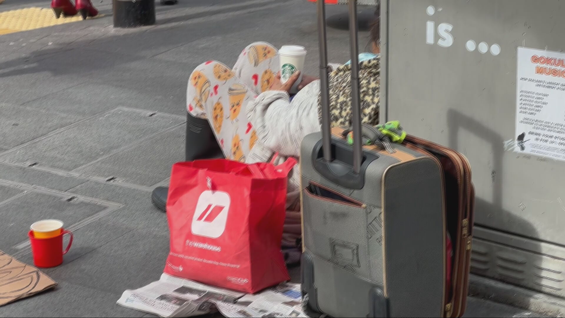 A person sits on the street. 