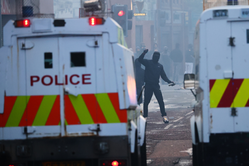 Police vehicles come under attack from protesters following a stabbing incident in Belfast