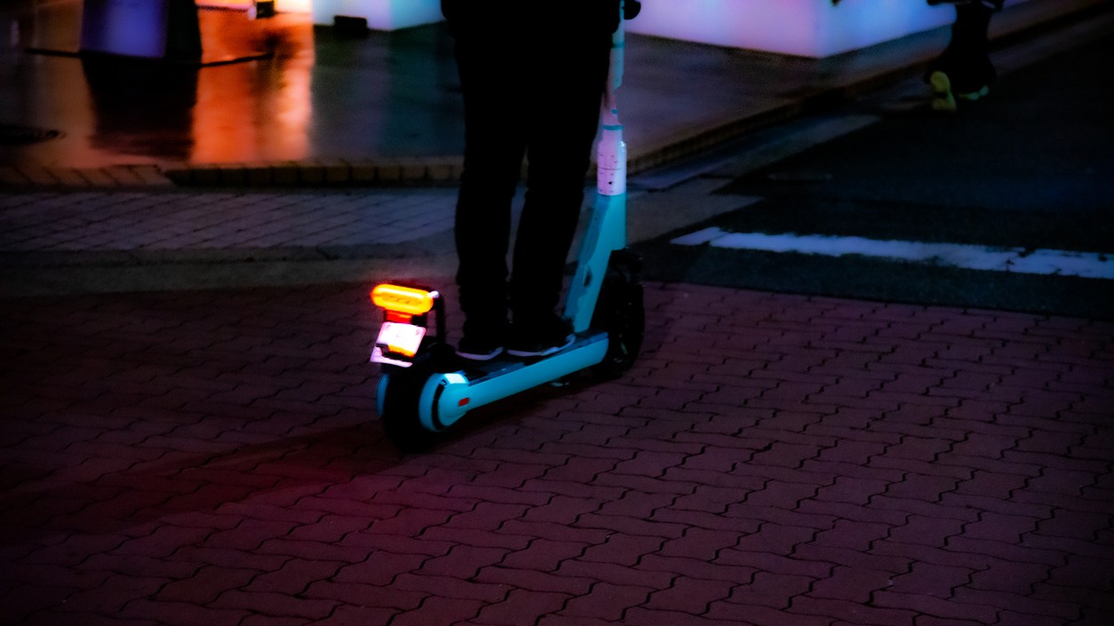 E-scooter being ridden at night.
