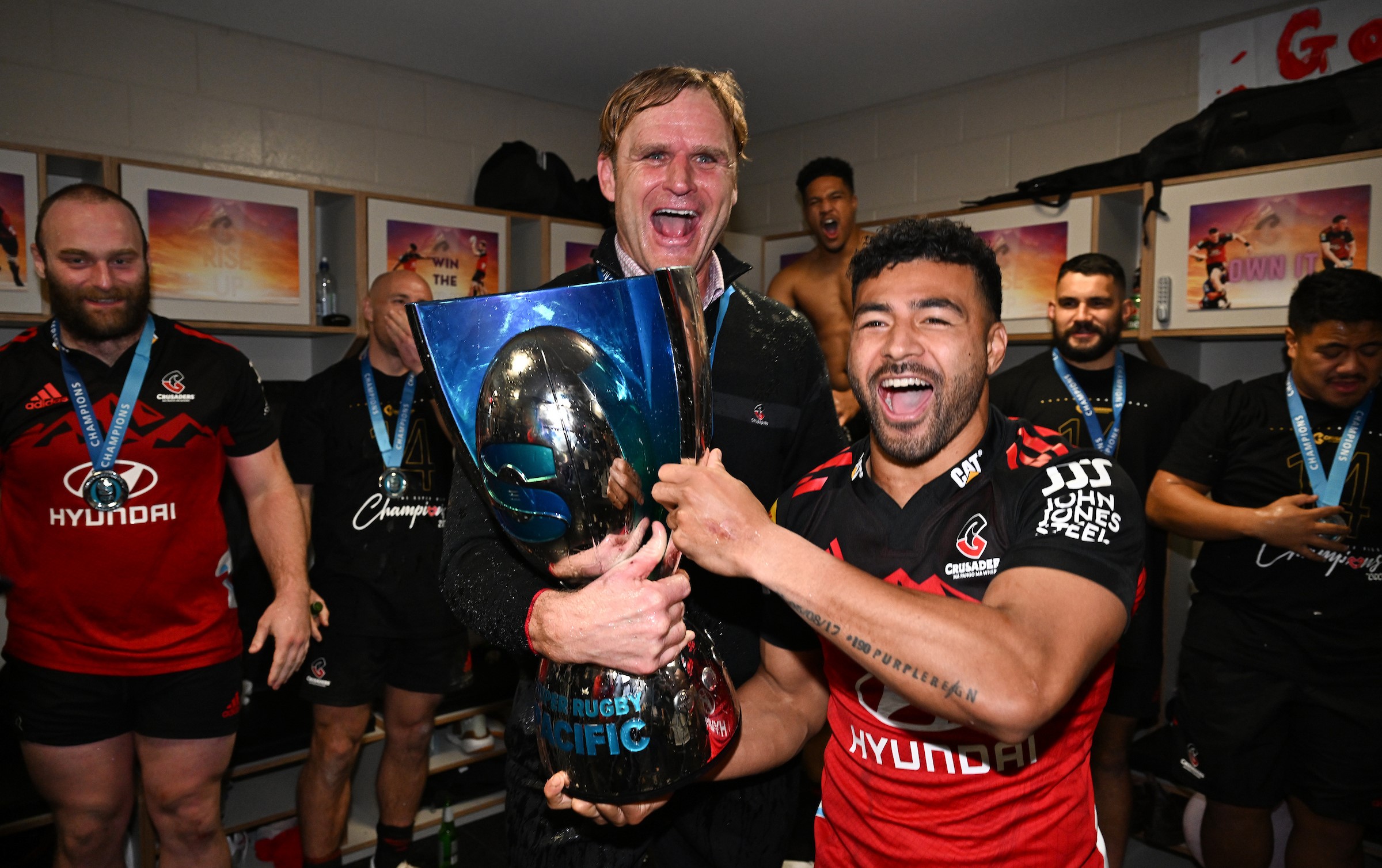 Mo'unga celebrates a Super Rugby final victory with Crusaders head coach Scott Robertson.