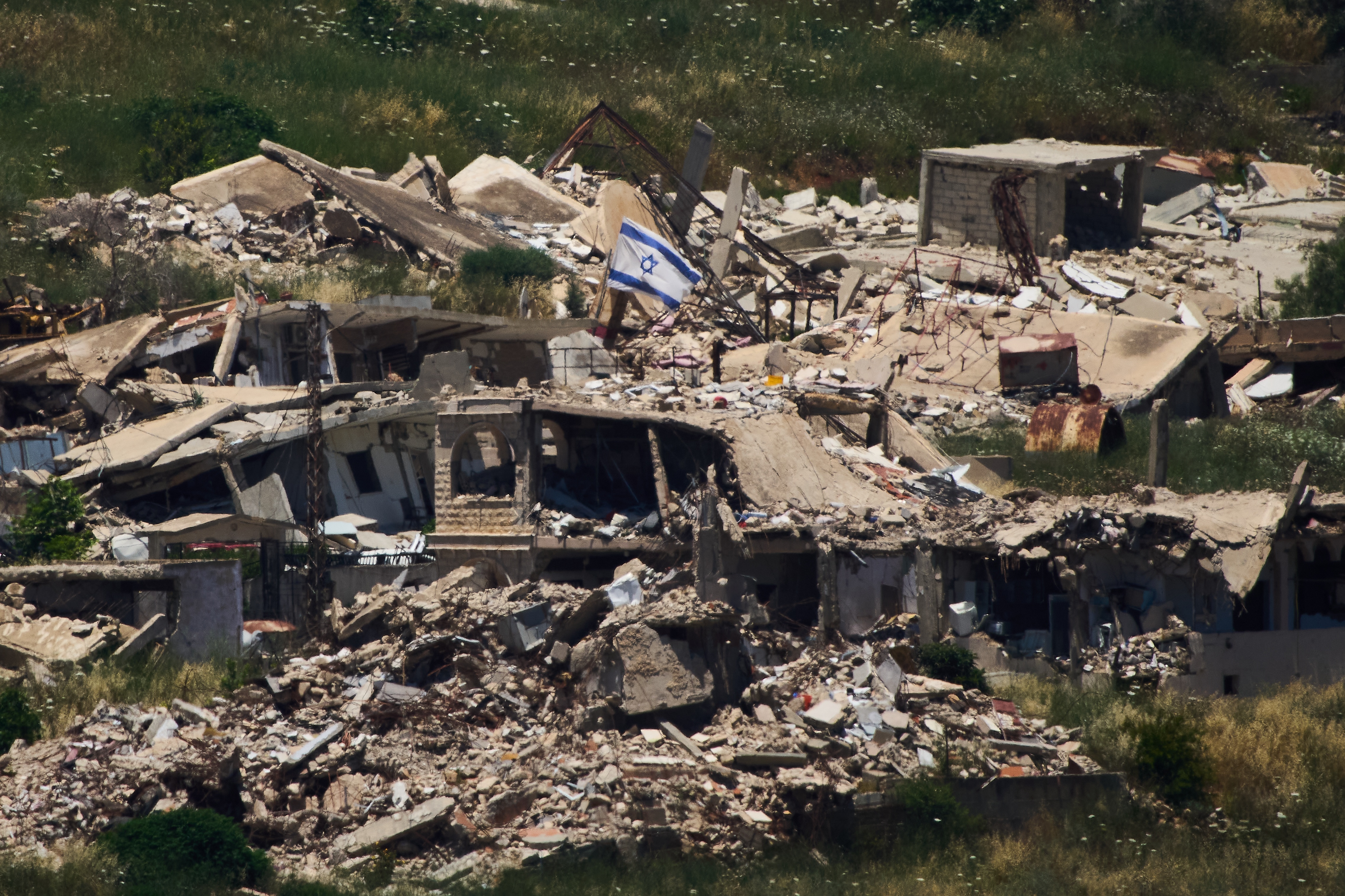 An Israeli flag hangs on a destroyed building in southern Lebanon as seen from northern Israel, Thursday June 4, 2026.