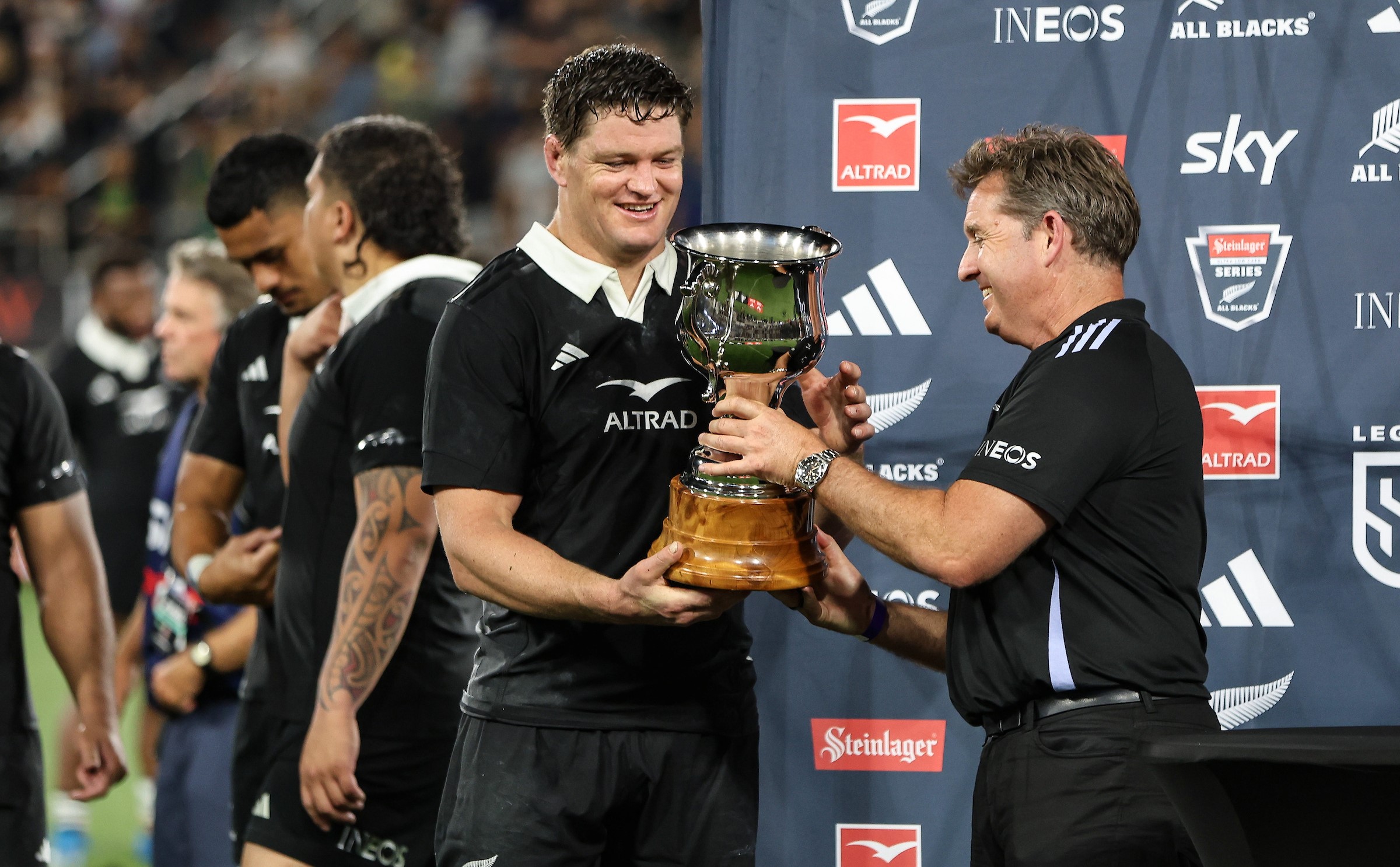NZ Rugby boss Mark Robinson presents All Blacks skipper Scott Barrett with a trophy after his team's win over Fiji last year.