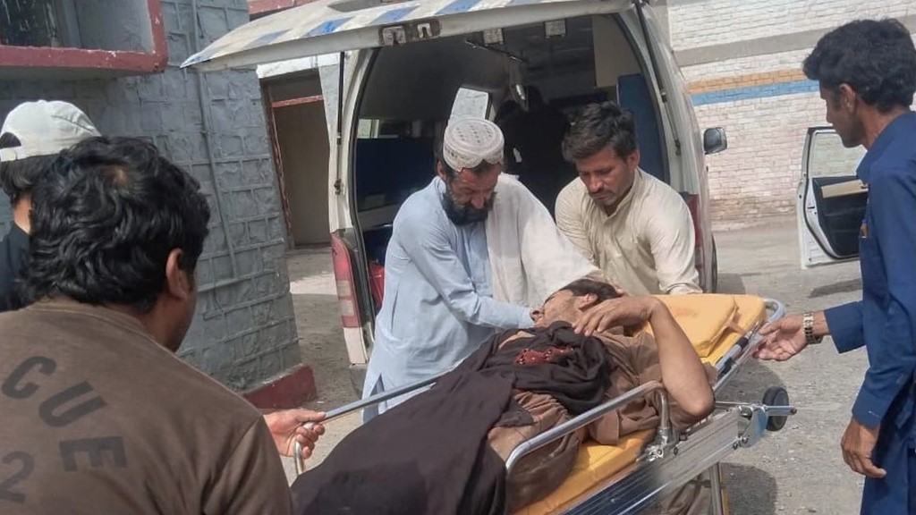 Rescue workers and volunteers transport an injured victim at a hospital after an overcrowded passenger bus plunged from a highway into a rocky ravine in Pakistan.