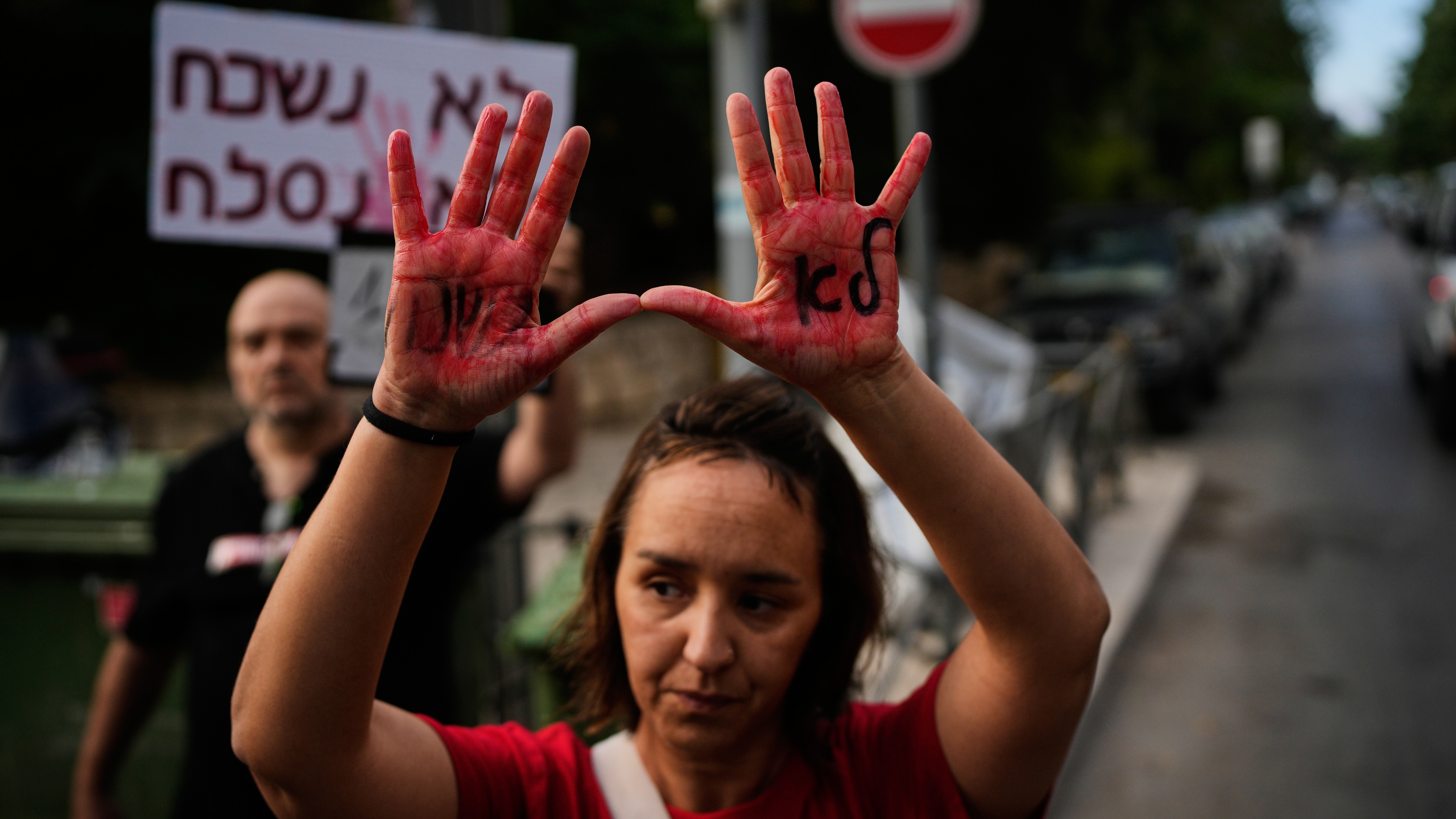 A woman holds up her hands, painted red to symbolize blood with the words in Hebrew "we will not forget" during a protest marking 1,000 days since the October 7 2003 Hamas-led attack on Israel, outside the prime minister residence in Jerusalem, Thursday, July 2, 2026.