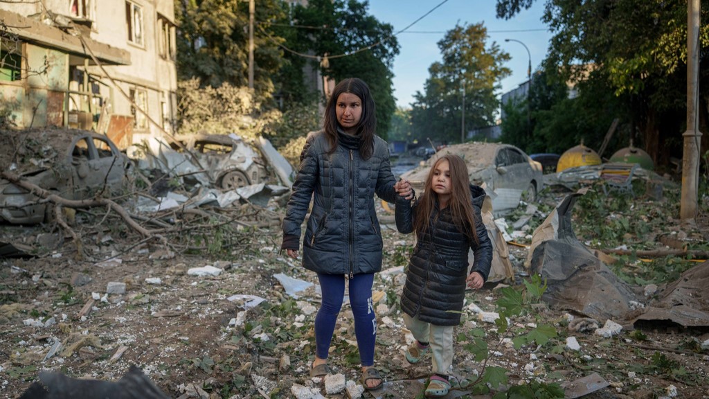 Olga Mudra, 35, and her daughter Natalia, 6, walk in the yard of their house damaged after a Russian strike on Kyiv, Ukraine, on Tuesday, June 2, 2026.