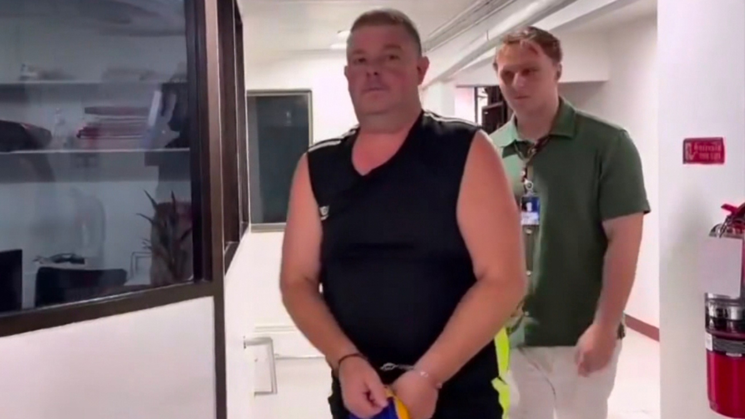  Simon Peter Carman, left, is led through a police station in Pattaya, Thailand.