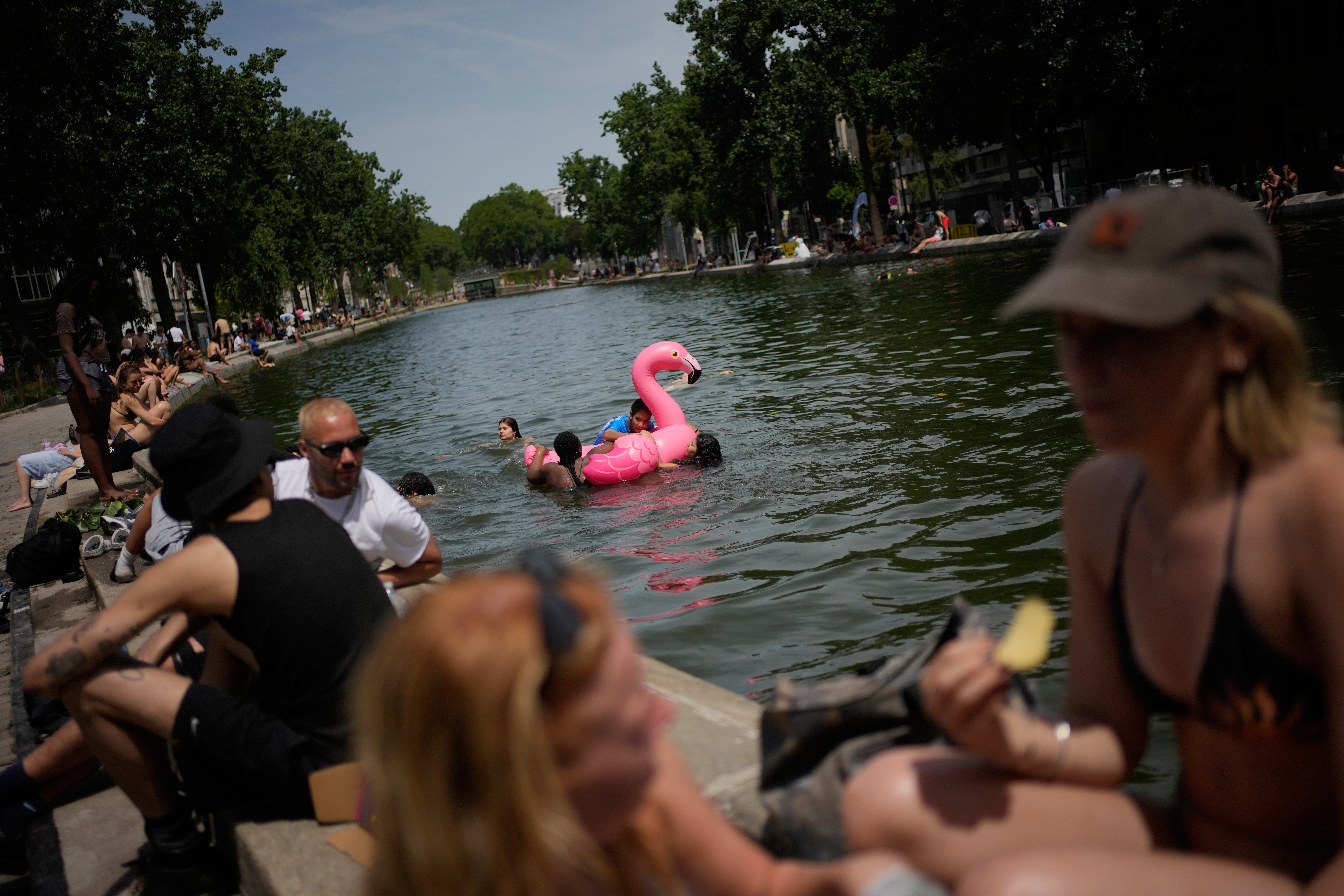 Parisians bath in the Canal Saint-Martin in Paris, as the national weather service, Meteo France, placed 54 departments, about half the country, under a red heat wave alert.