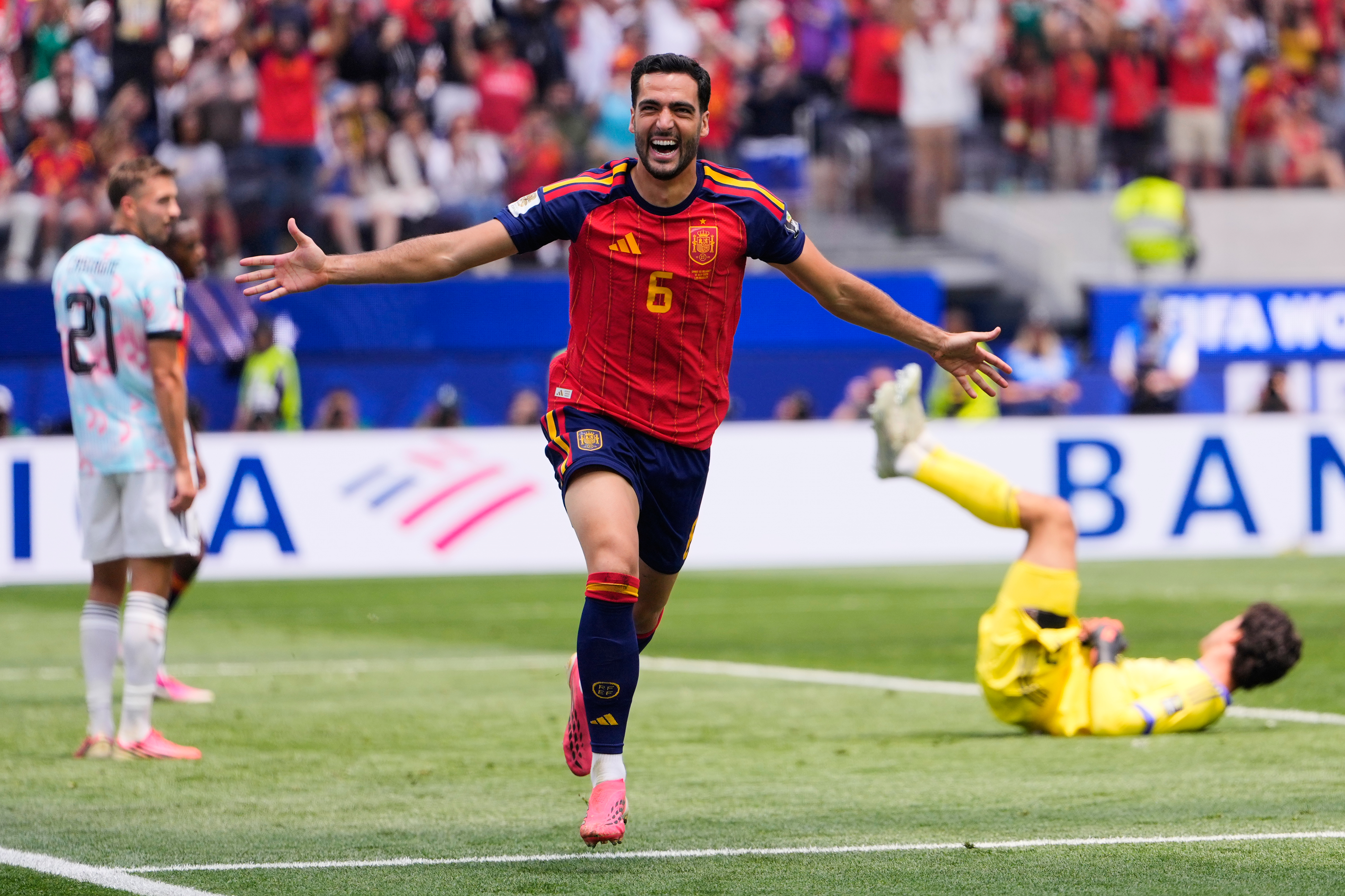 Spain's Mikel Merino (6) celebrates scoring their second goal in front of Belgium's Timothy Castagne (21) and goalkeeper Senne Lammens (12) during the World Cup quarterfinal s