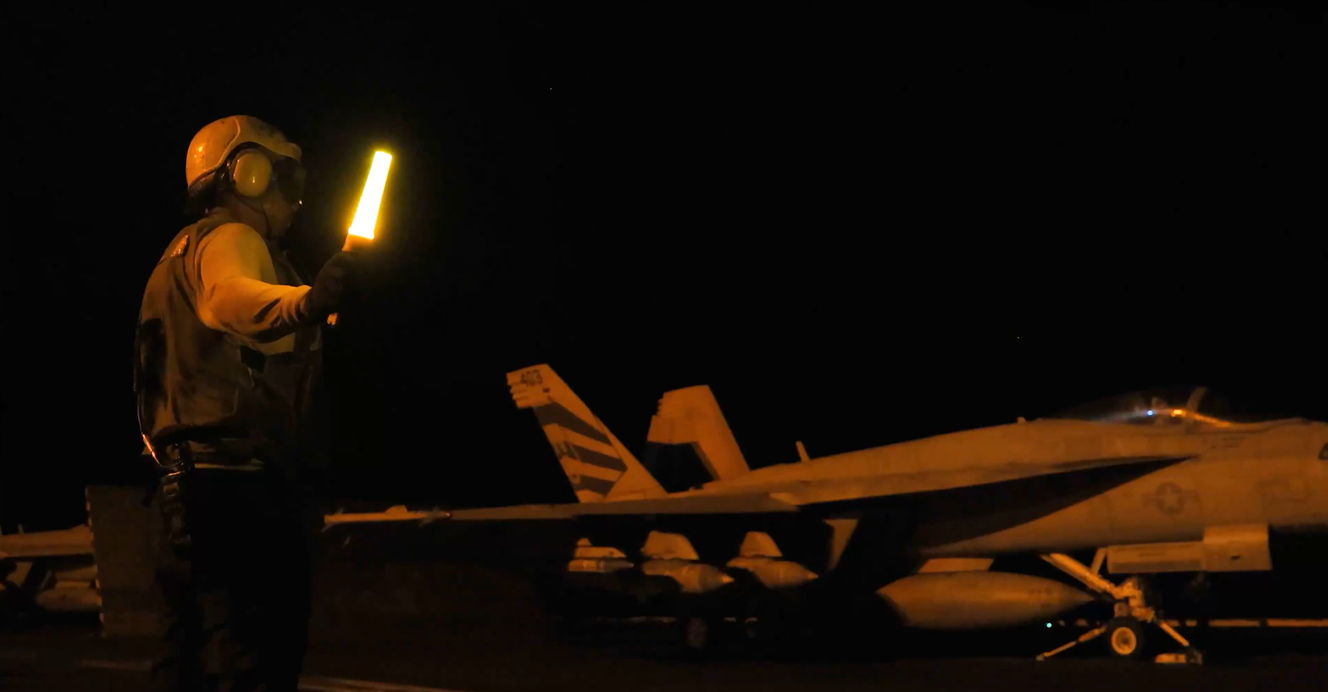 A screenshot from a video shared by the US military showing a jet taking off from an aircraft carrier.