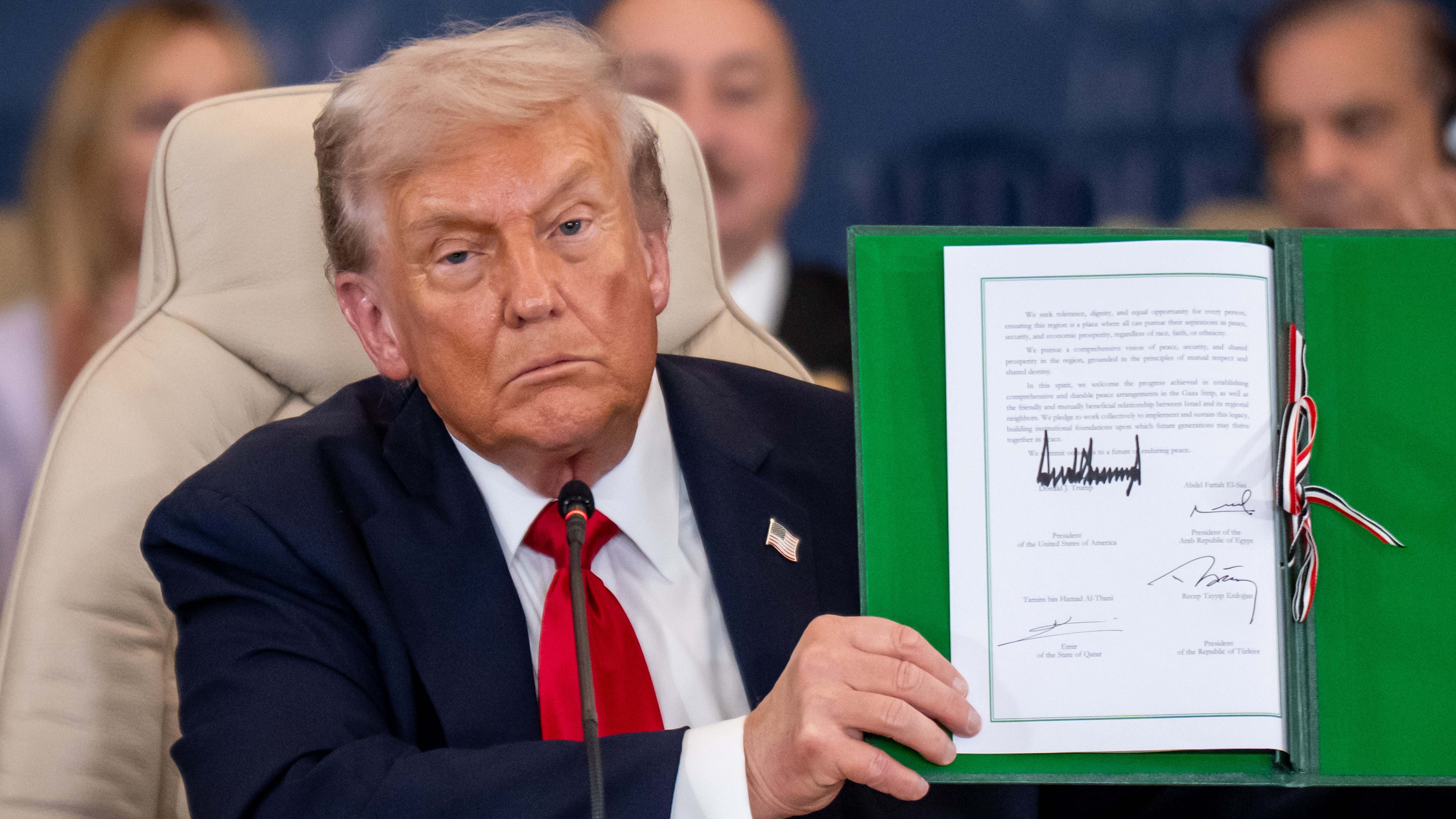 US President Donald Trump shows the signed peace treaty at the Gaza summit chaired by Egypt's President Al-Sisi in Scharm El Scheich. 