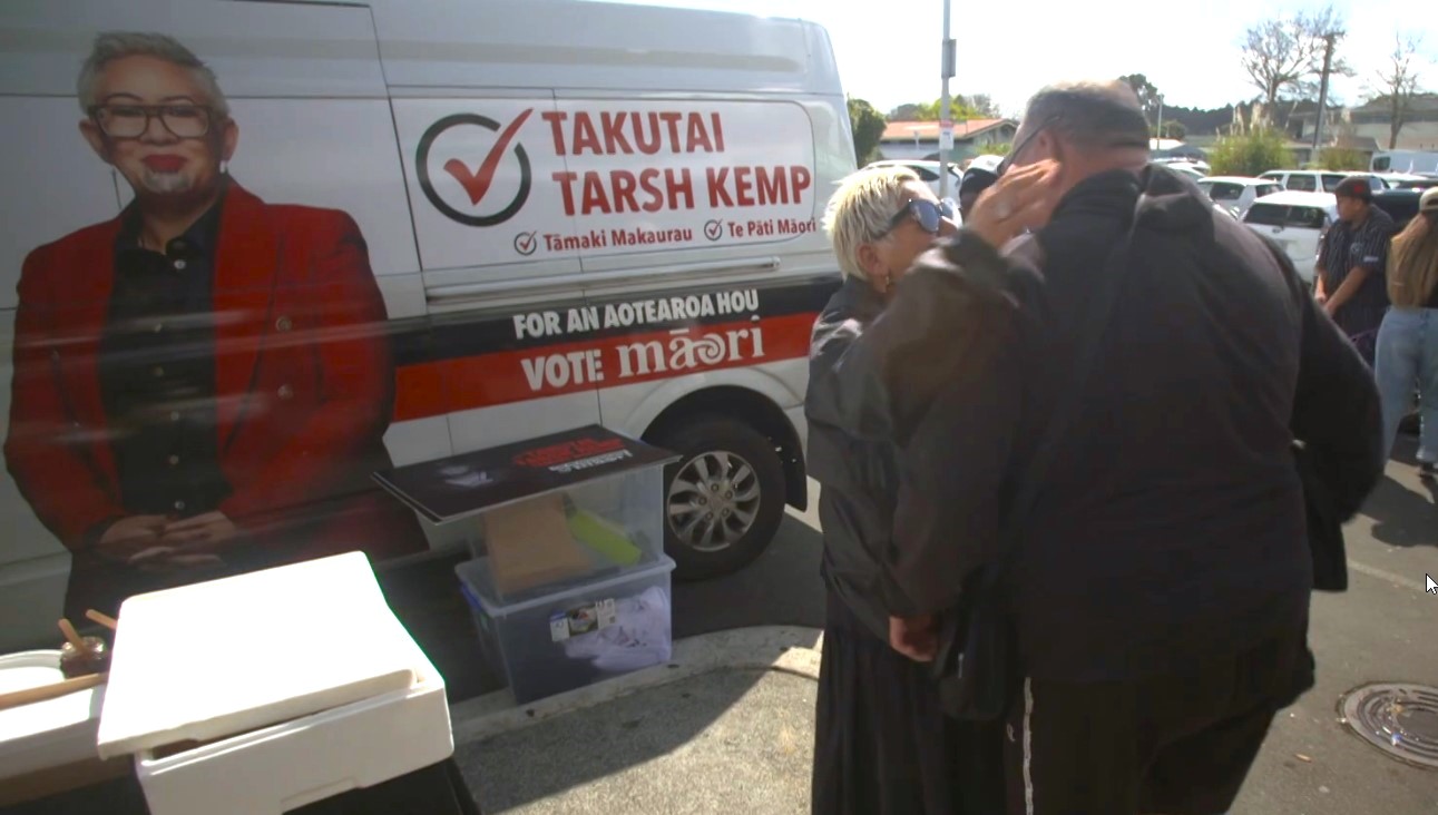 Takutai Tarsh Kemp stands in front of a branded van.