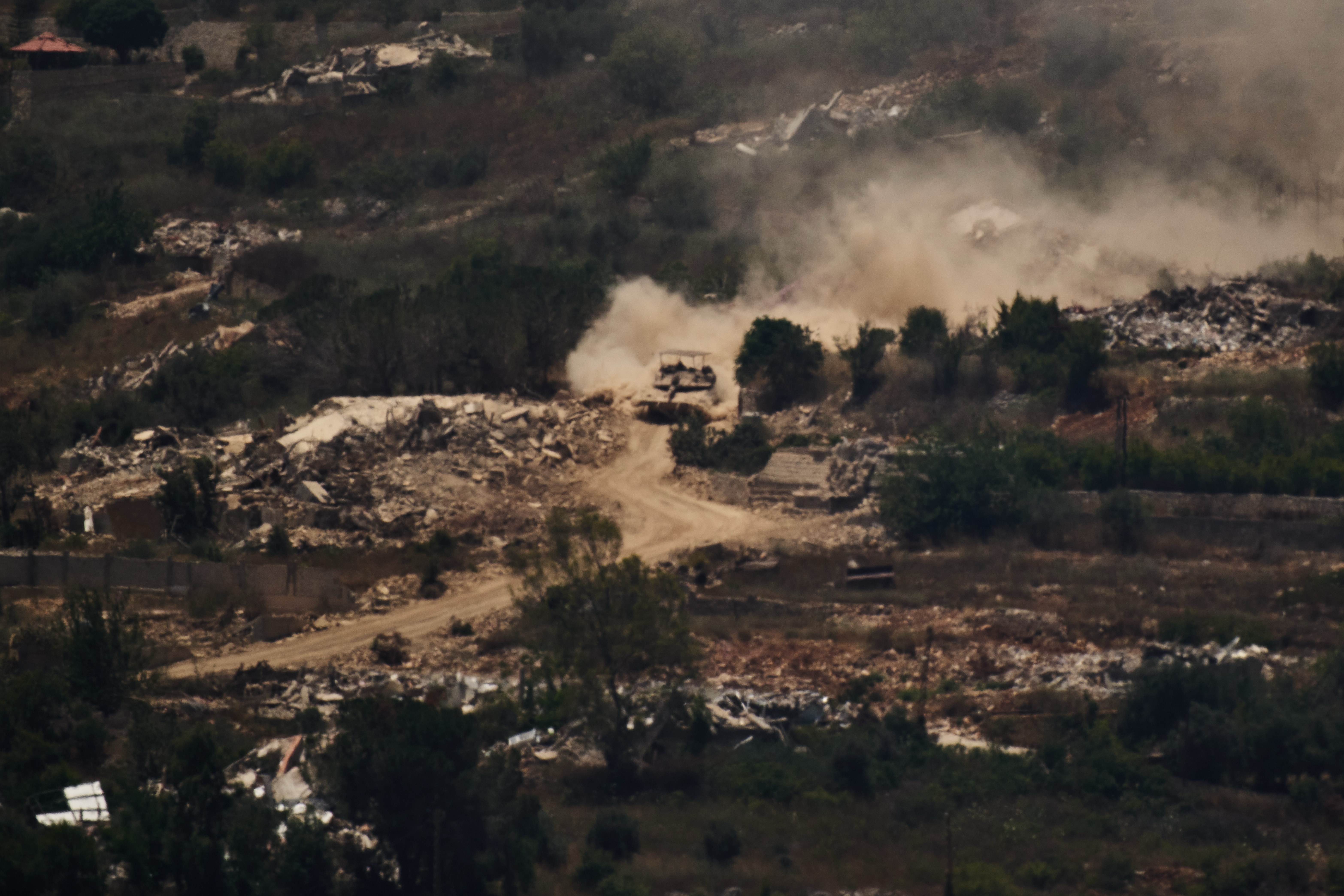 An Israeli tank moves past destroyed buildings in southern Lebanon as seen from northern Israel, Friday, June 26, 2026.